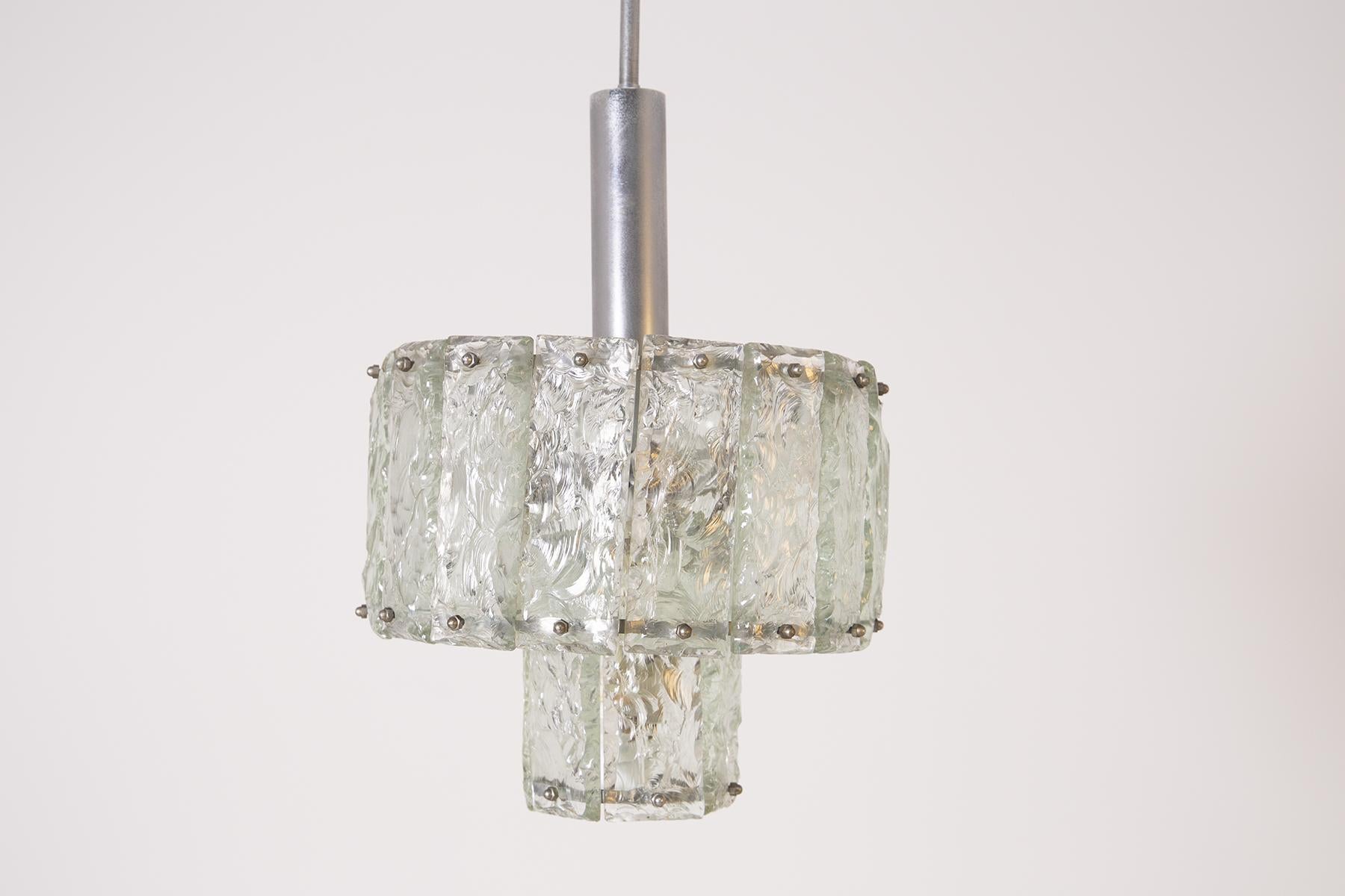 Long Italian pendant chandelier from 1960. The chandelier has a nickel-plated brass frame. Its shade is composed of several pieces of hand-hammered glass. The lampshade is composed of a first smaller sequence of hammered glass inside the lamp and a