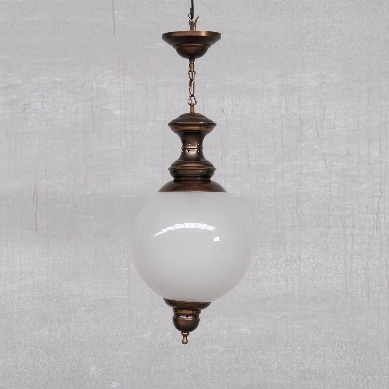 Una lampada a sospensione della metà del XX secolo attribuita a Luigi Caccia Dominioni. 

Italia, anni '60 circa. 

Ottone patinato e sfera in vetro acidato. 

Alcuni graffi e usura commisurati all'età ma in generale buone condizioni. 

Da