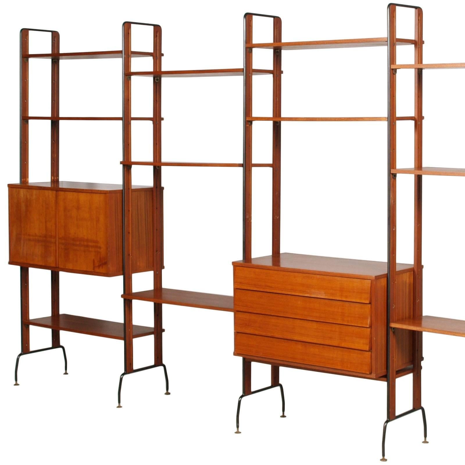 1950s number three book shelfs with storage units, La Permanente Mobili di Cantu, Franco Albini Franca Helg manner in solid teak wood, teak wood veneer of storage cabinets and structure in black lacquered steel. Adjustable brass feet and brass