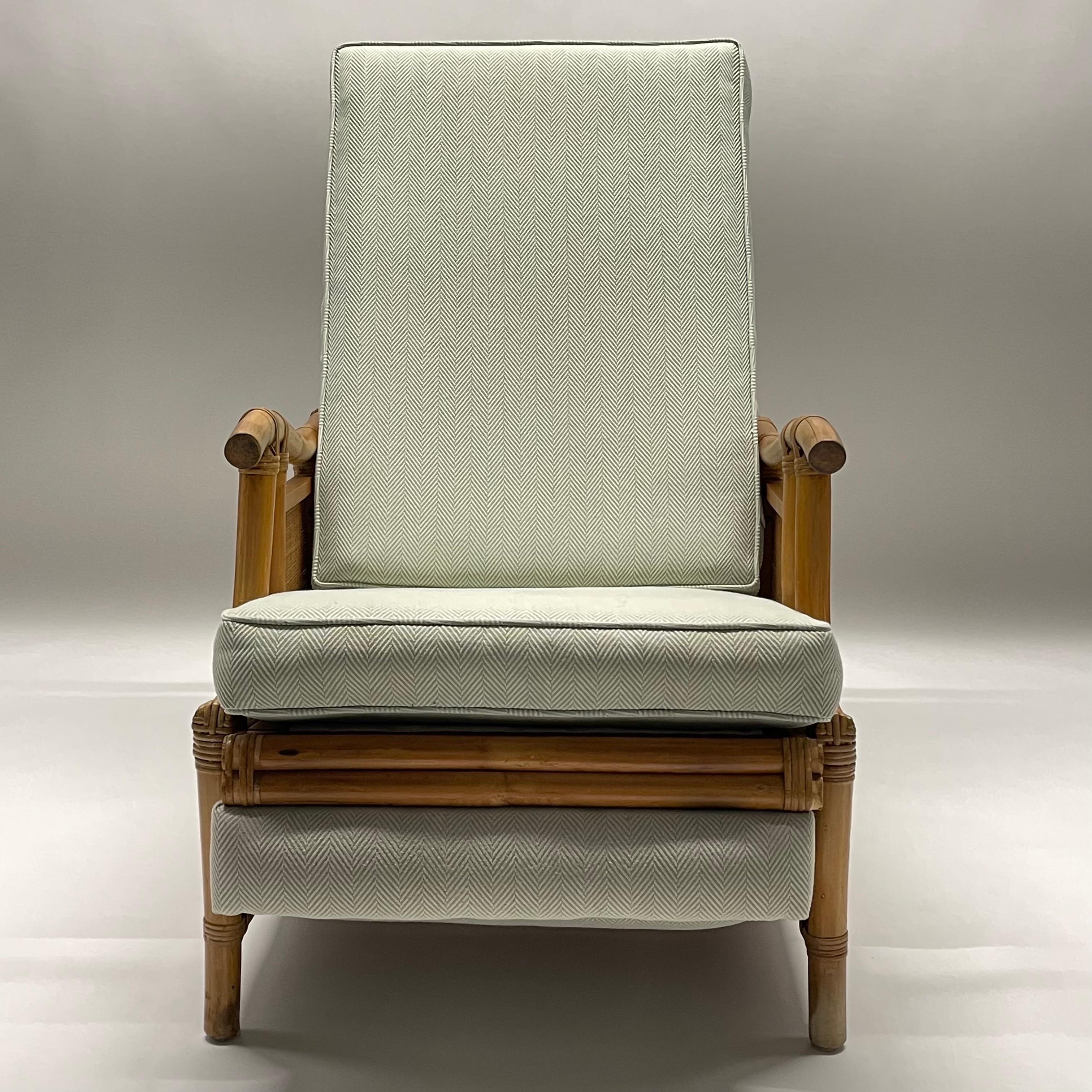 Rare midcentury recliner lounge chair rendered in rattan wicker bamboo and cane with recently upholstered fully removable high-end sage gray green woven herringbone fabric back and seat cushions. Two position reclining options for added comfort, by