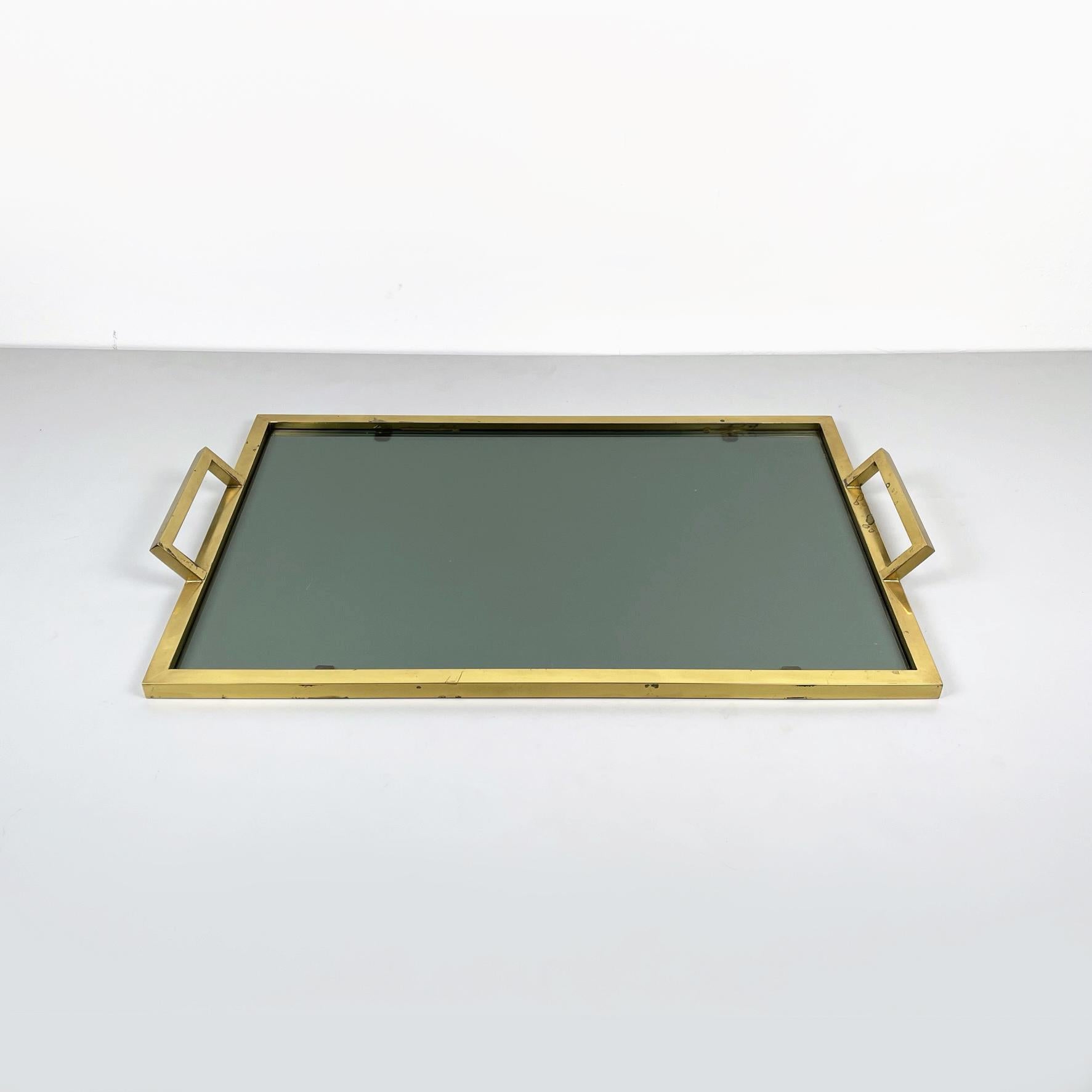 Italian mid-century Rectangular tray in brass and smoked glass, 1960s
Tray with rectangular top in smoked glass. The structure and the two handles are square section and entirely in brass. It can be used as a serving tray or as a decorative
