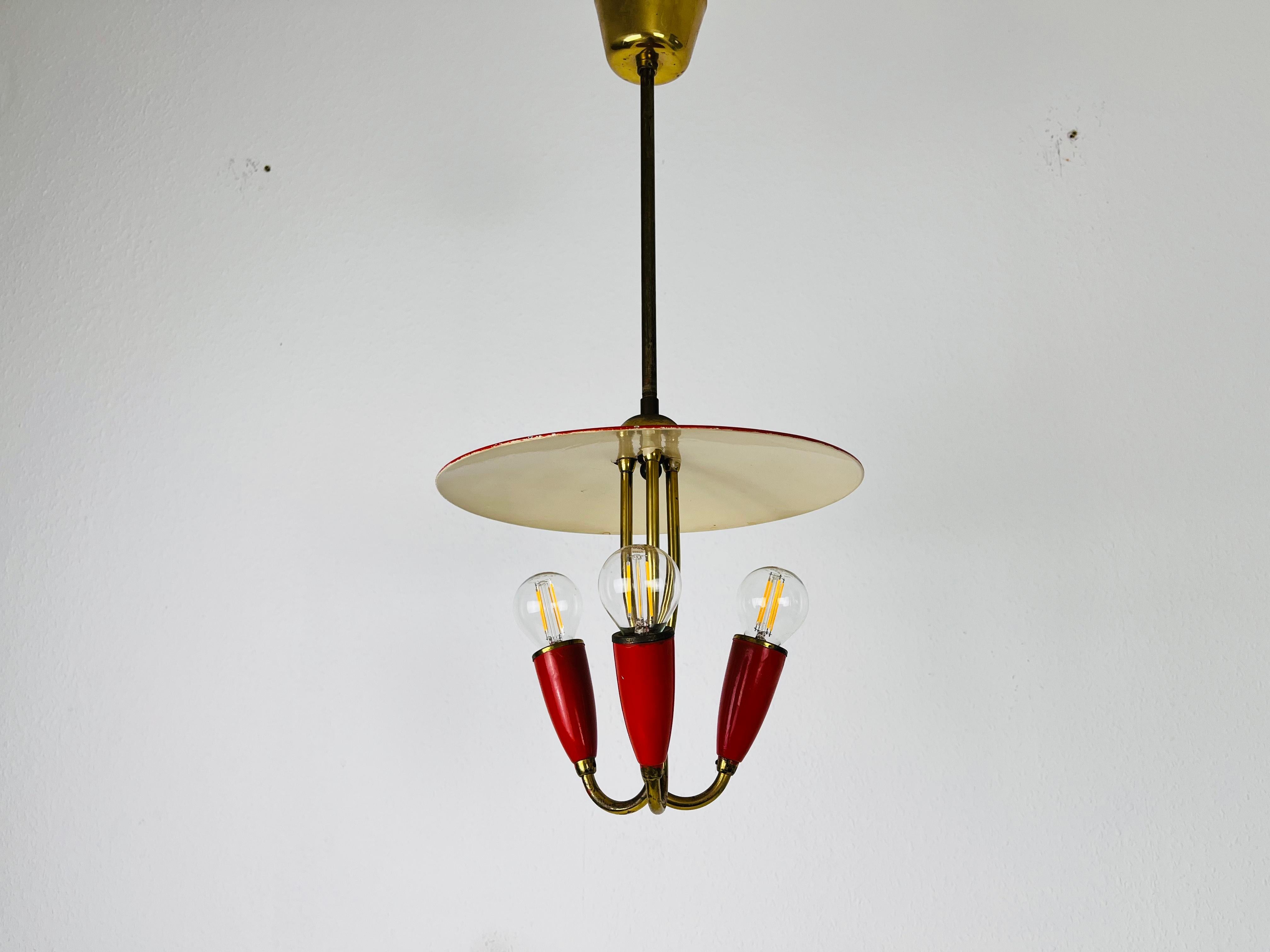 A Sputnik chandelier made in Italy in the 1960s. It is fascinating with its three red arms, each of it with an E14 light bulb. 

The light requires 3 E14 light bulbs. Works with both 120/220V. Good vintage condition.

Free worldwide express