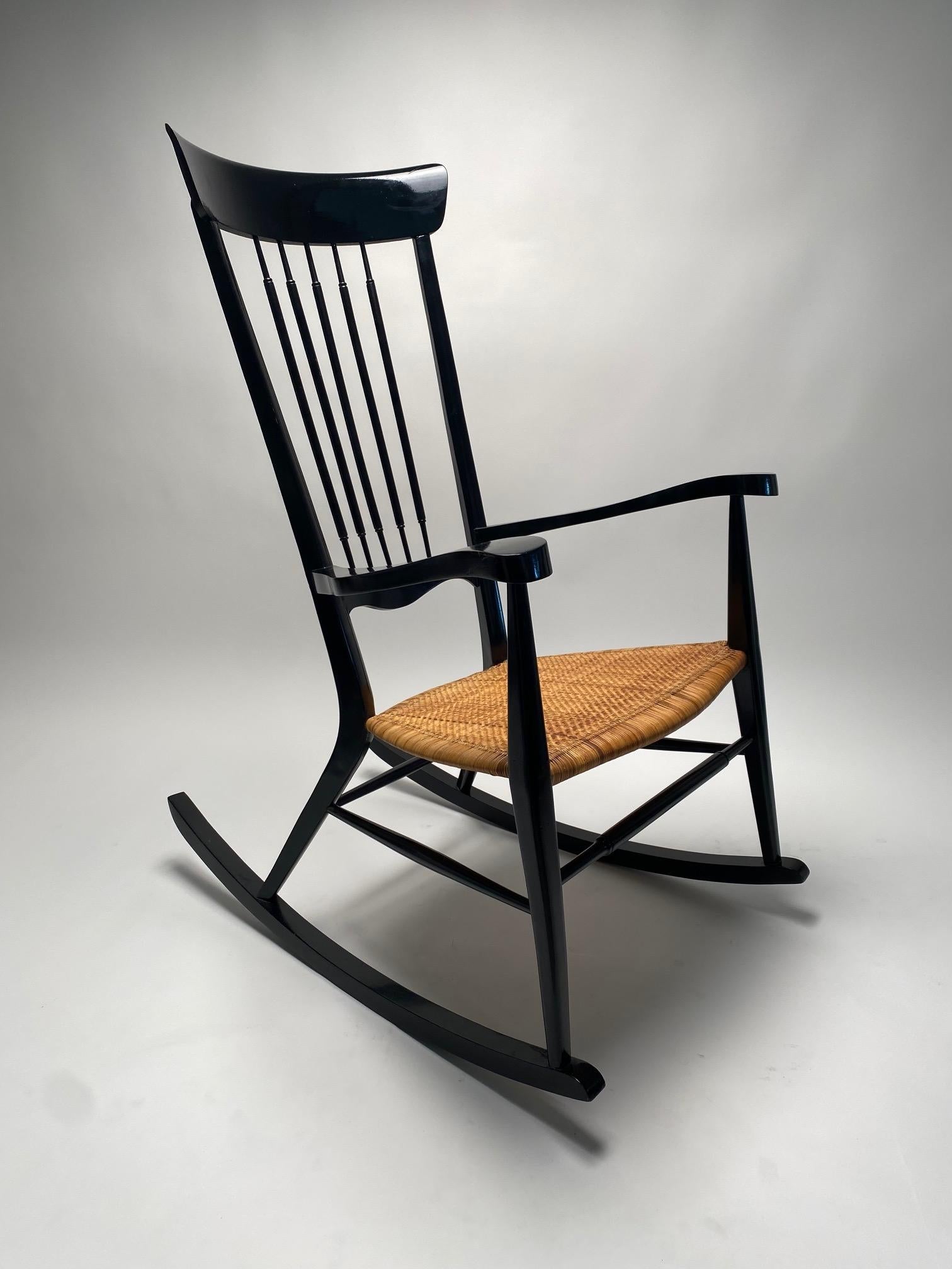 Rare Italian Mid-Century Rocking chair, in the style of Paolo Buffa, made in the 1950s.

This rocking chair in black lacquered wood, with seat in woven straw, is an iconic and highly refined example of Italian design. With its slender and elegant