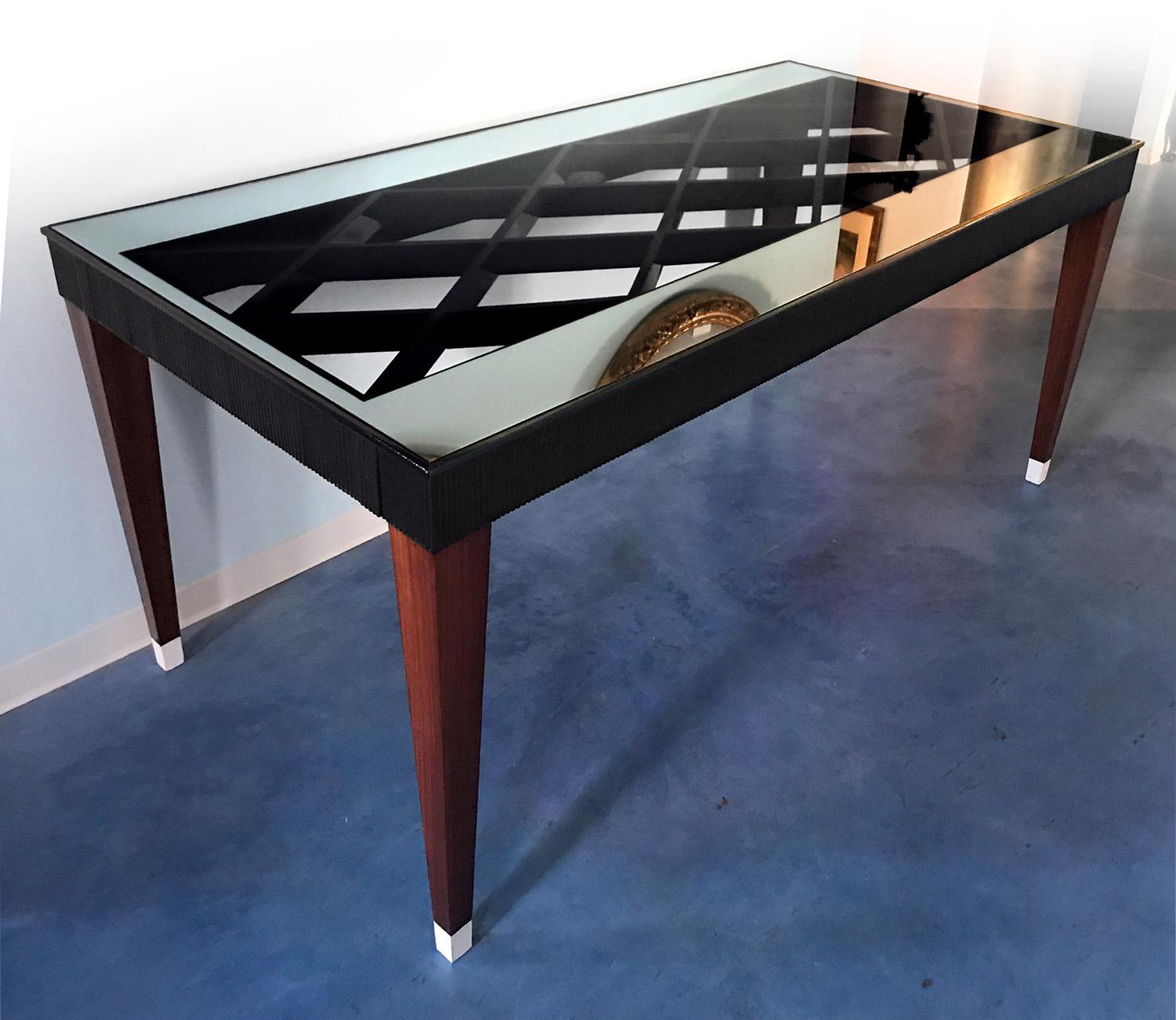 Le design de cette merveilleuse table de salle à manger est attribué à Paolo Buffa dans les années 1950.
Il présente un design sculpté unique, très élégant et charmant, caractérisé par une structure aux formes géométriques en bois noir laqué, avec