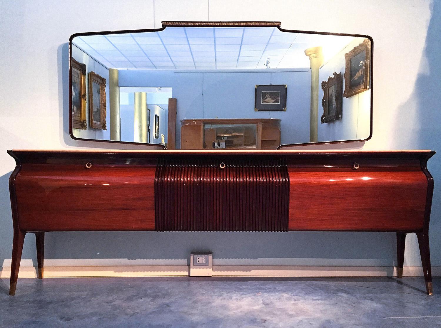 Spectacular and stylish sideboard or credenza designed by Osvaldo Borsani in the 1952.
The structure is made in rosewood with a unique design, characterized by its amazing curved profile very detailed and surmounted, on the marble top panel, by