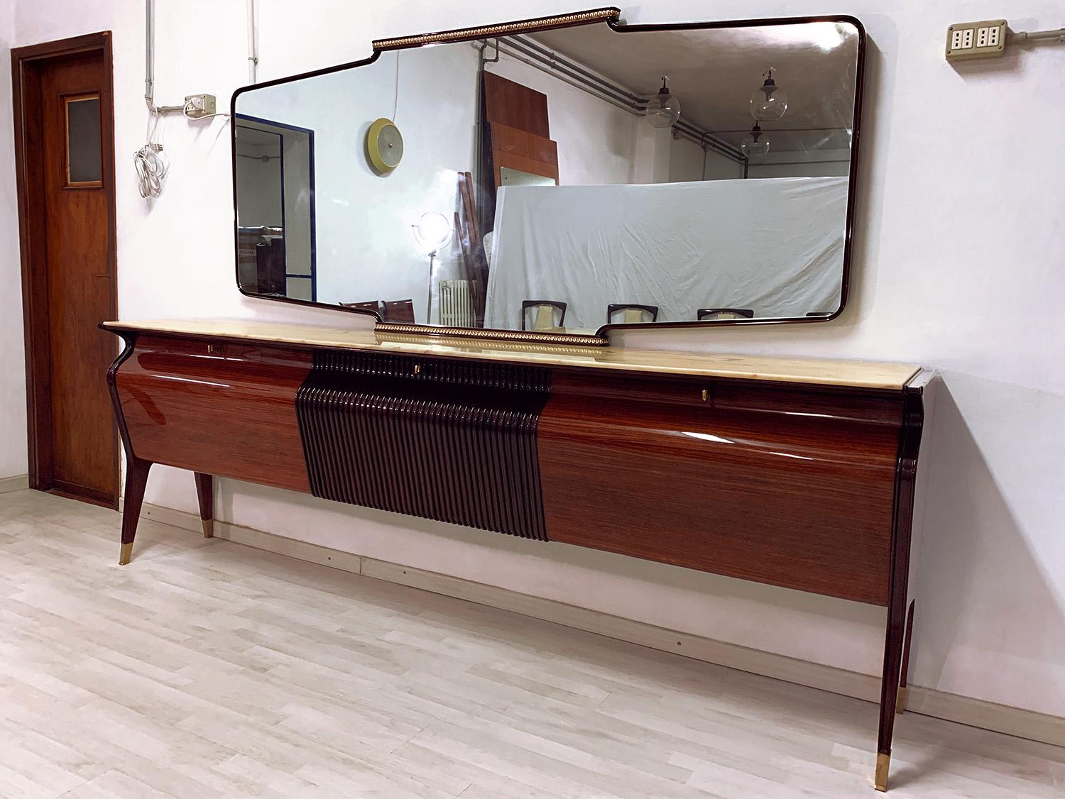 Impressive Sideboard and/or Buffet with mirror designed by Osvaldo Borsani in the 1950s.
Its structure is made of rosewood, characterized by a unique shape design, given by its sinuous frontal profile equipped with three drop-down doors.
Very