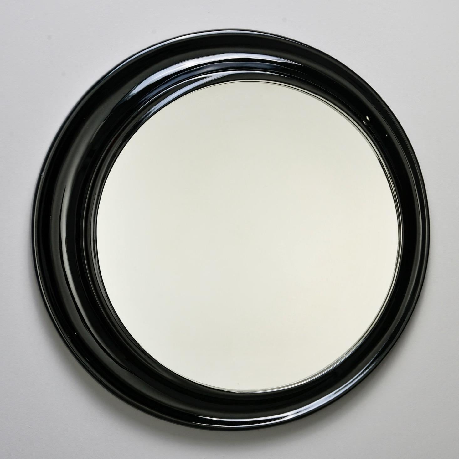 Italian round mirror features a deep set black frame with one edge wider and slightly off-center, circa 1970s. Actual mirror is 24” diameter. Unknown maker.
  