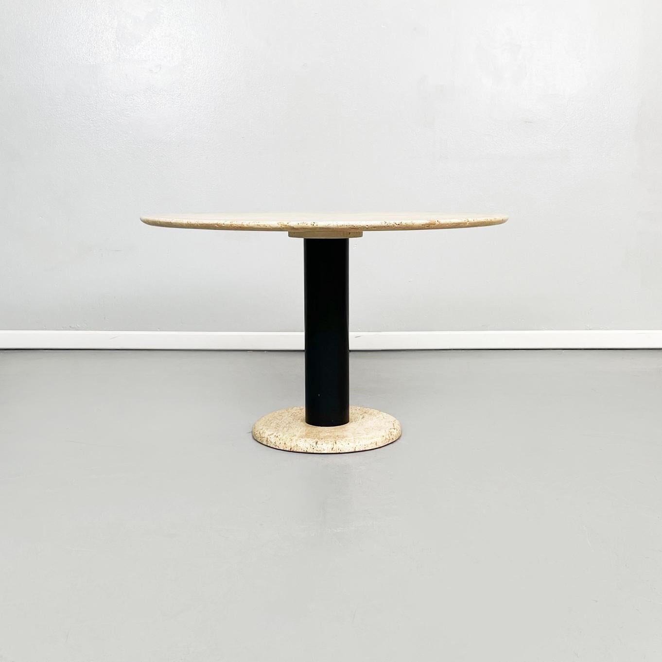 Italian mid-century Round travertine and black metal coffee table, 1970s
Round coffee table with travertine top. The top is a thin slab of travertine, resting on a cylindrical leg in black painted metal. The round base is in