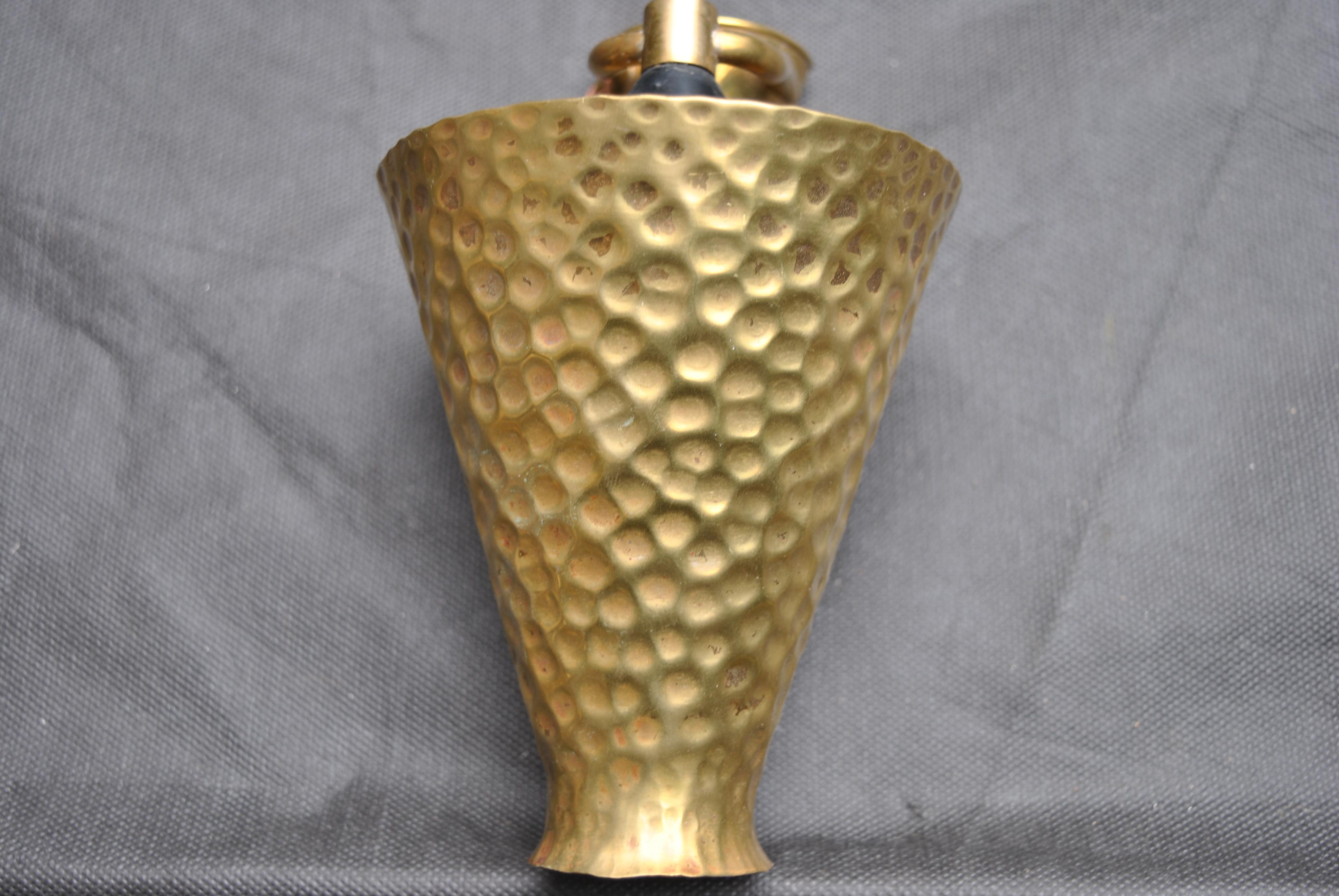 A beautiful pair of sconces an Italian production form the fifties in hammered brass.