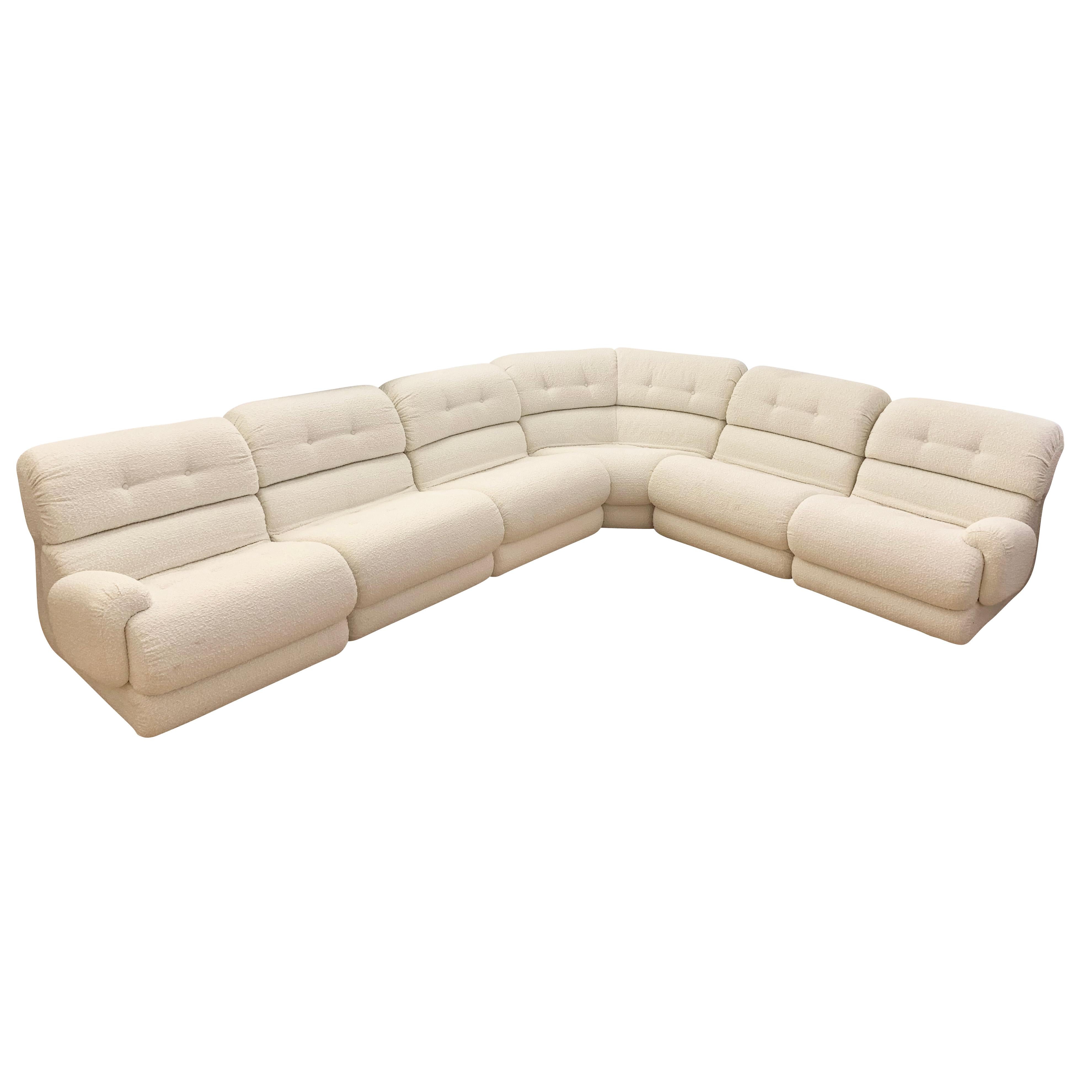 Italian Mid-Century sectional recovered in an off-white boucle fabric. Each piece can be easily separated for individual use or to create a variety of layouts. Composed of the following pieces.

1 angular section: 57W x 36D x 32H

3 sections without