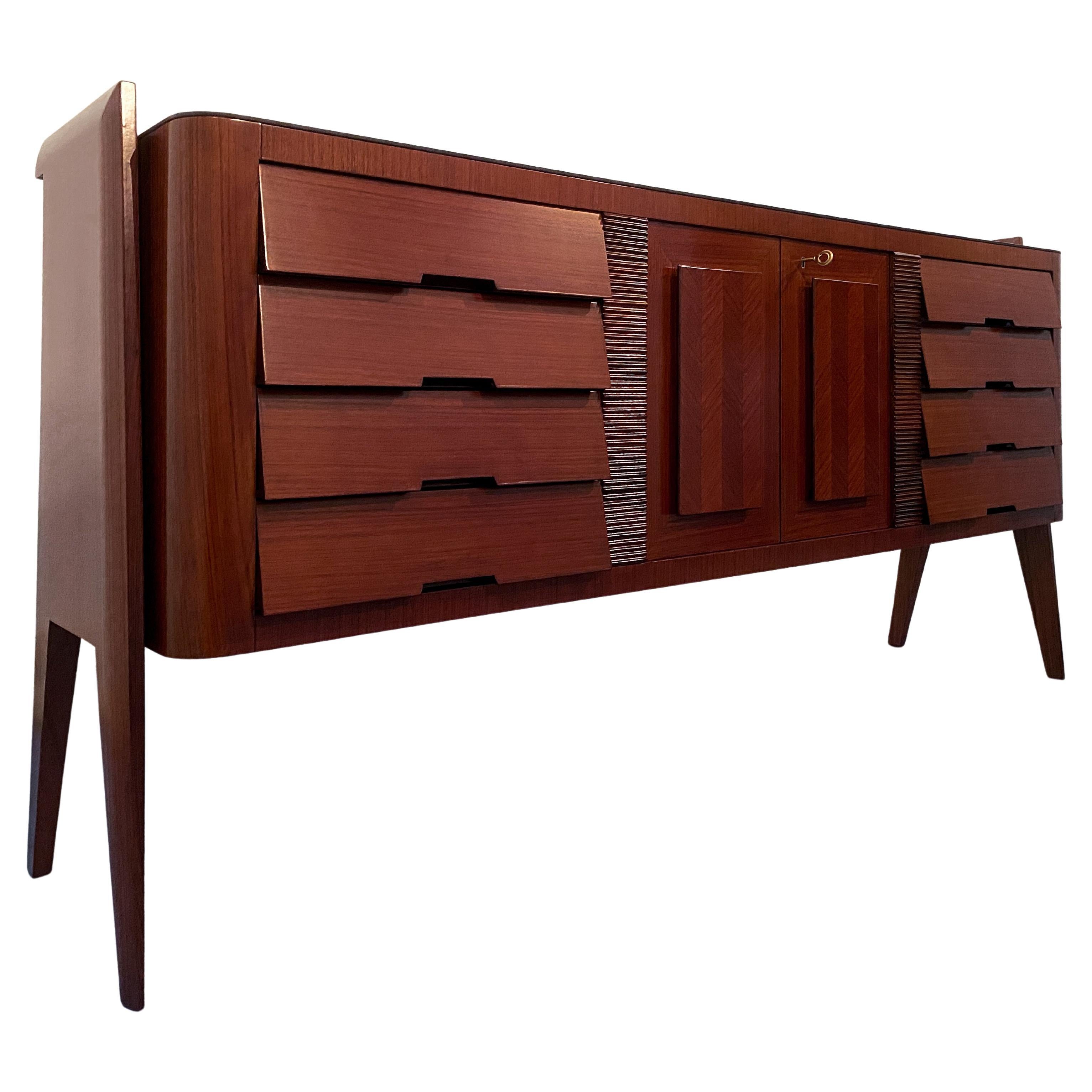The Italian credenza or sideboard bar by Vittorio Dassi is a refined piece of furniture, featuring a glass top and maple interiors. The front is made up of eight drawers and two doors, and it has been crafted with great attention to execution