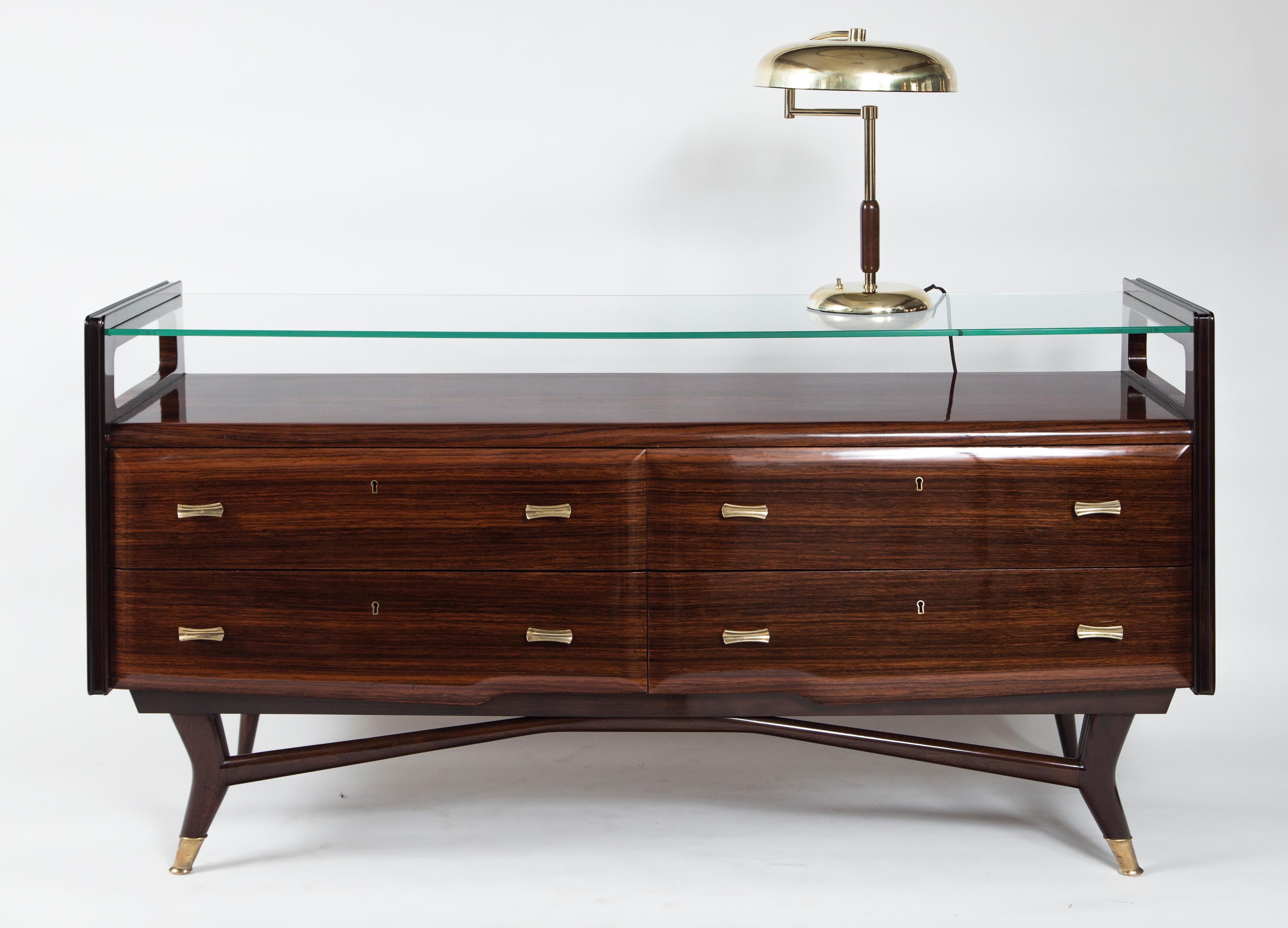 Stunning console cabinet with floating glass top above a rosewood veneer base composed of four drawers with rectangular-shaped brass pulls and finishing with angled front legs and brass sabots.

Condition: Excellent condition, re-polished.
  