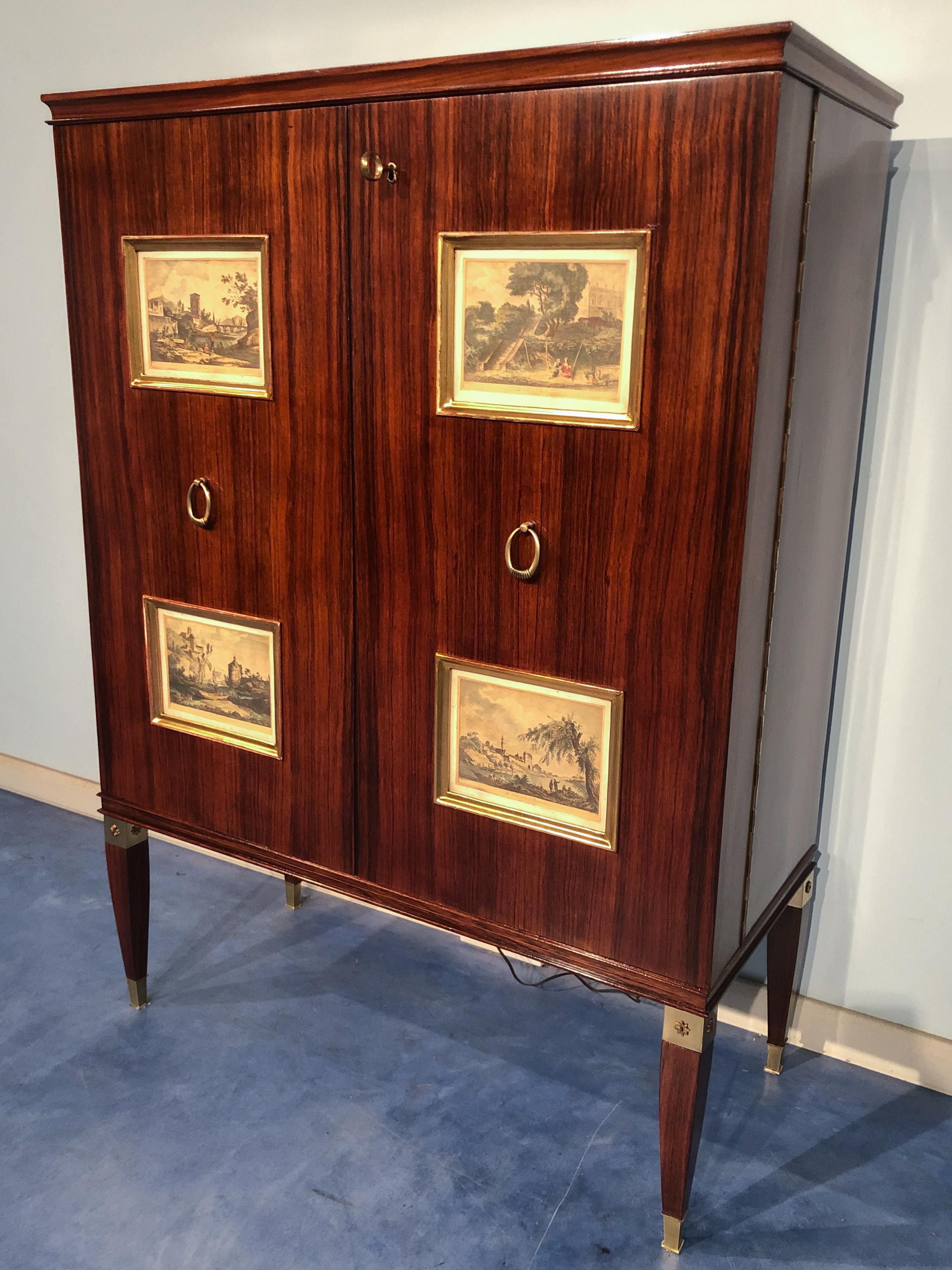 Italian mid-century cabinet bar or sideboard designed by Paolo Buffa in the 1950s. On the front doors, you find four giltwood panels, inserted with 18th-century engravings of classic scenes. The interior has drawers and mirrored shelves with stars