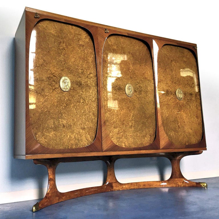 Rare sideboard three-doors designed by Vittorio Dassi in the 1950s.
It's a very fine item made using precious materials as well as the three-doors made of birch briar root, finished with brass medallions positioned at the center of each door.
In