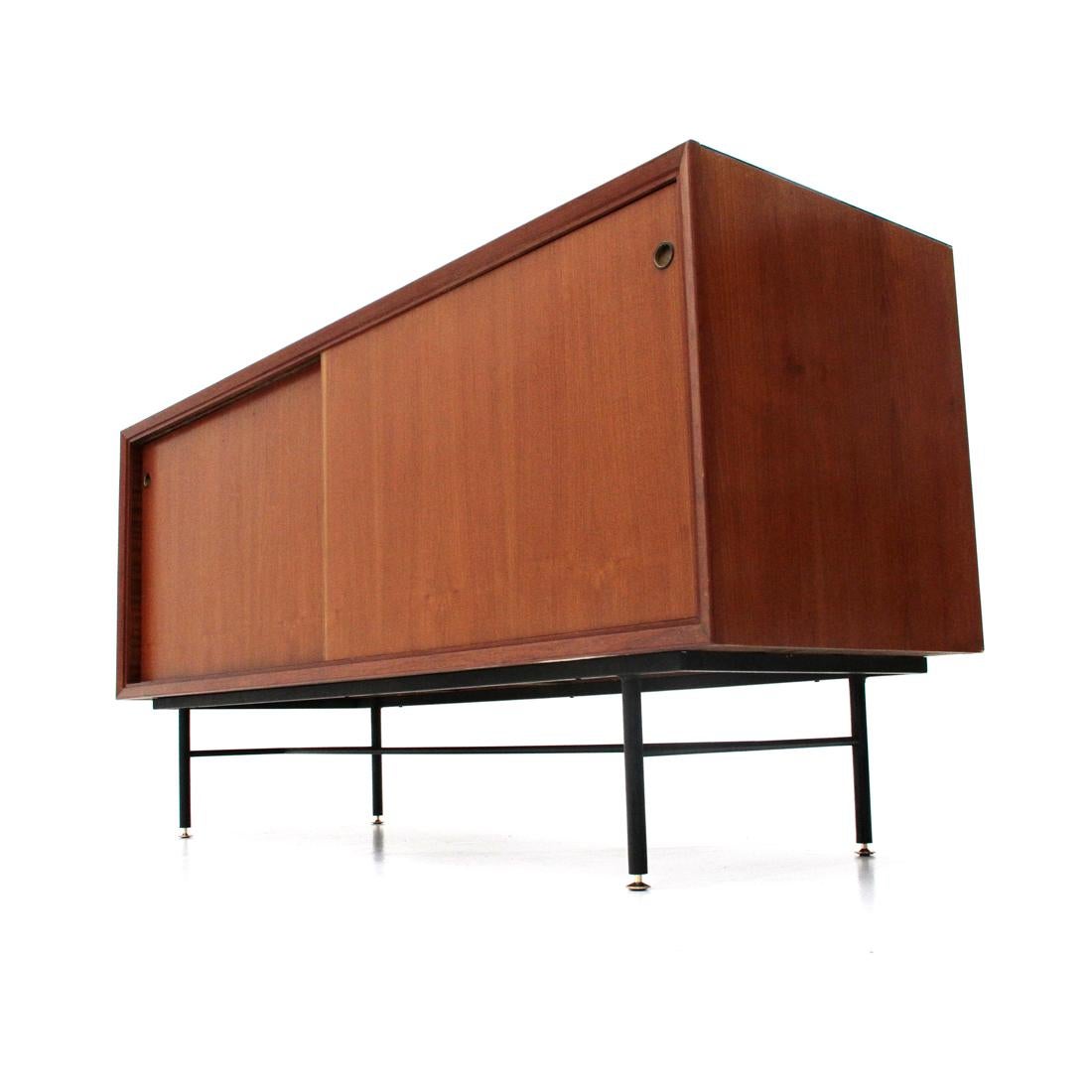 Italian manufacturing sideboard produced in the 1960s.
Veneered wood frame with solid wood front frames.
Upper top in black glass.
Sliding doors with brass handle.
Two compartments with shelf.
Legs in black painted metal with adjustable height