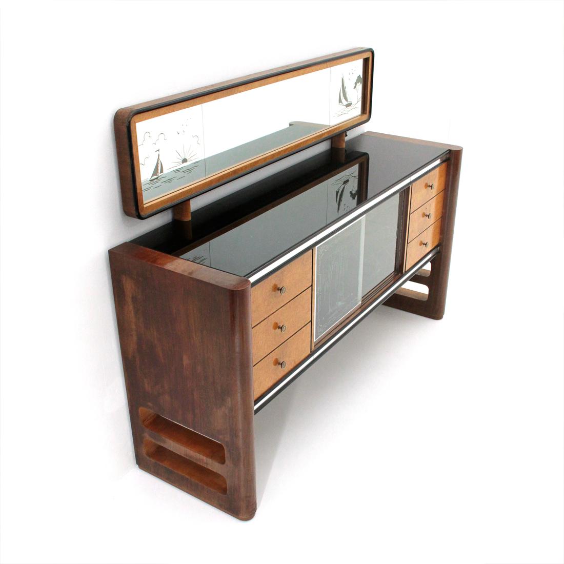 Sideboard produced in the 1950s by the Permanente del Mobile Cantù.
Side panels in veneered wood with a rounded front surface.
Central body in veneered wood.
Over and under front frames in mirror.
Side drawers veneered in briar with brass