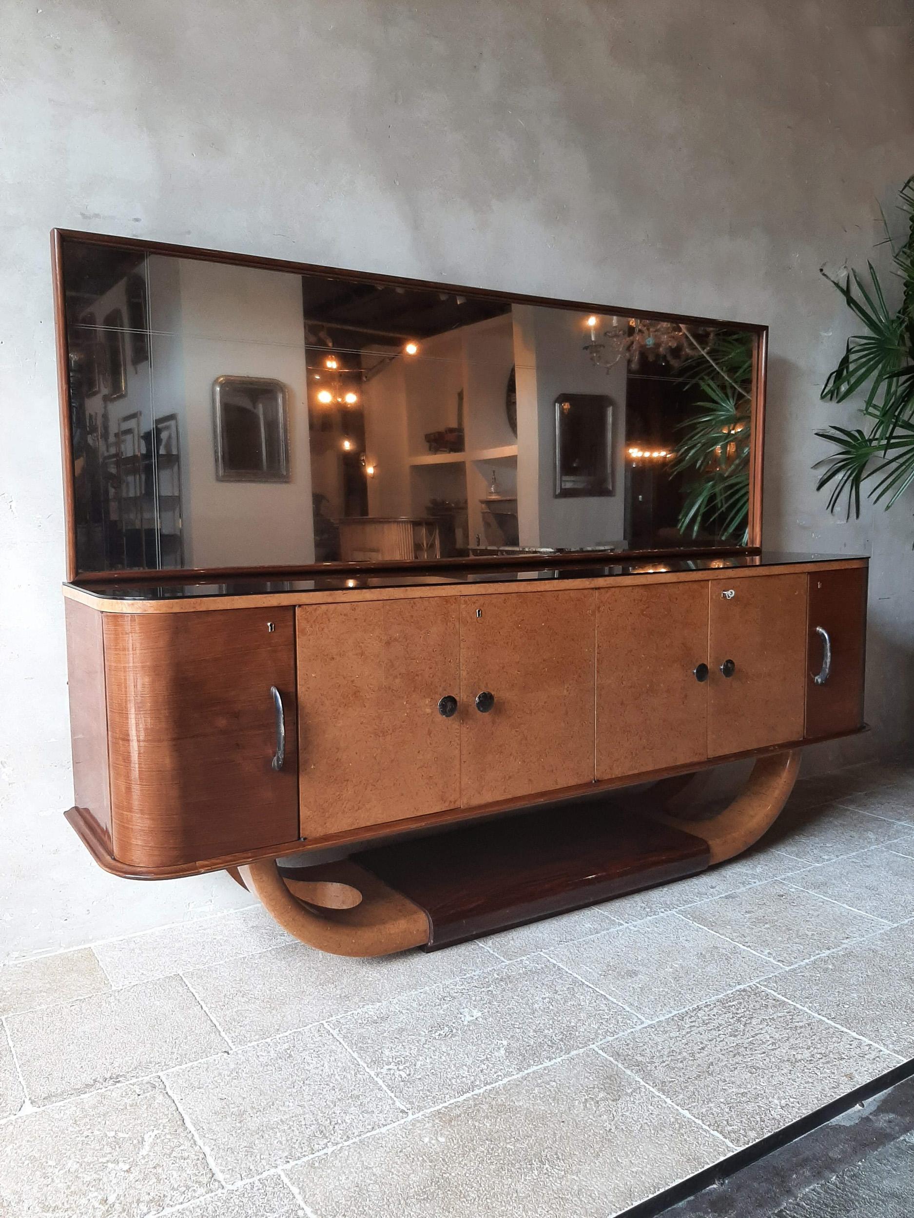 Italian mid-century sideboard with mirror attributed to Osvaldo Borsani from the 1940s. This large 250 cm wide cabinet is made from walnut with lacquered parts and burl wood veneer has 6 door with plywood shelving on the inside. The top shelve