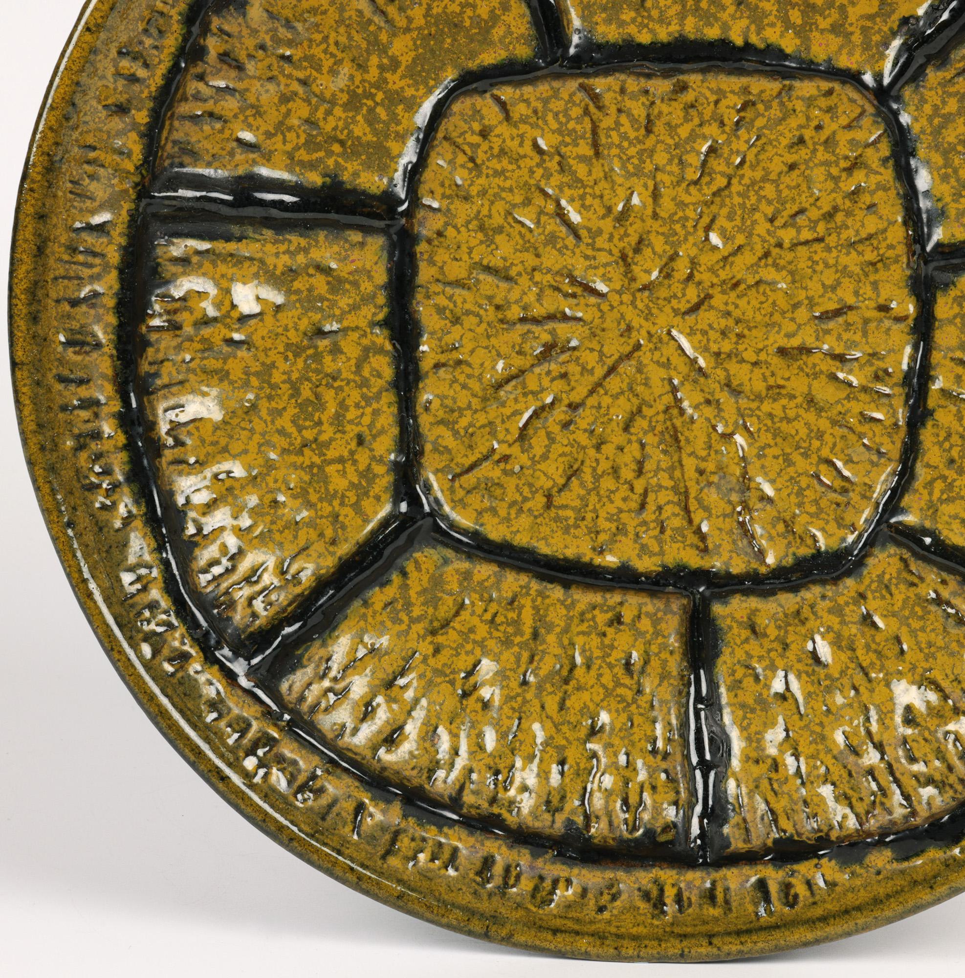 A stunning Italian mid-century modernist art pottery wall plaque or shallow bowl decorated with a textured design and signed to the base. The heavily hand-made red clay plaque is of rounded form with a raised rim and is decorated with a raised wheel