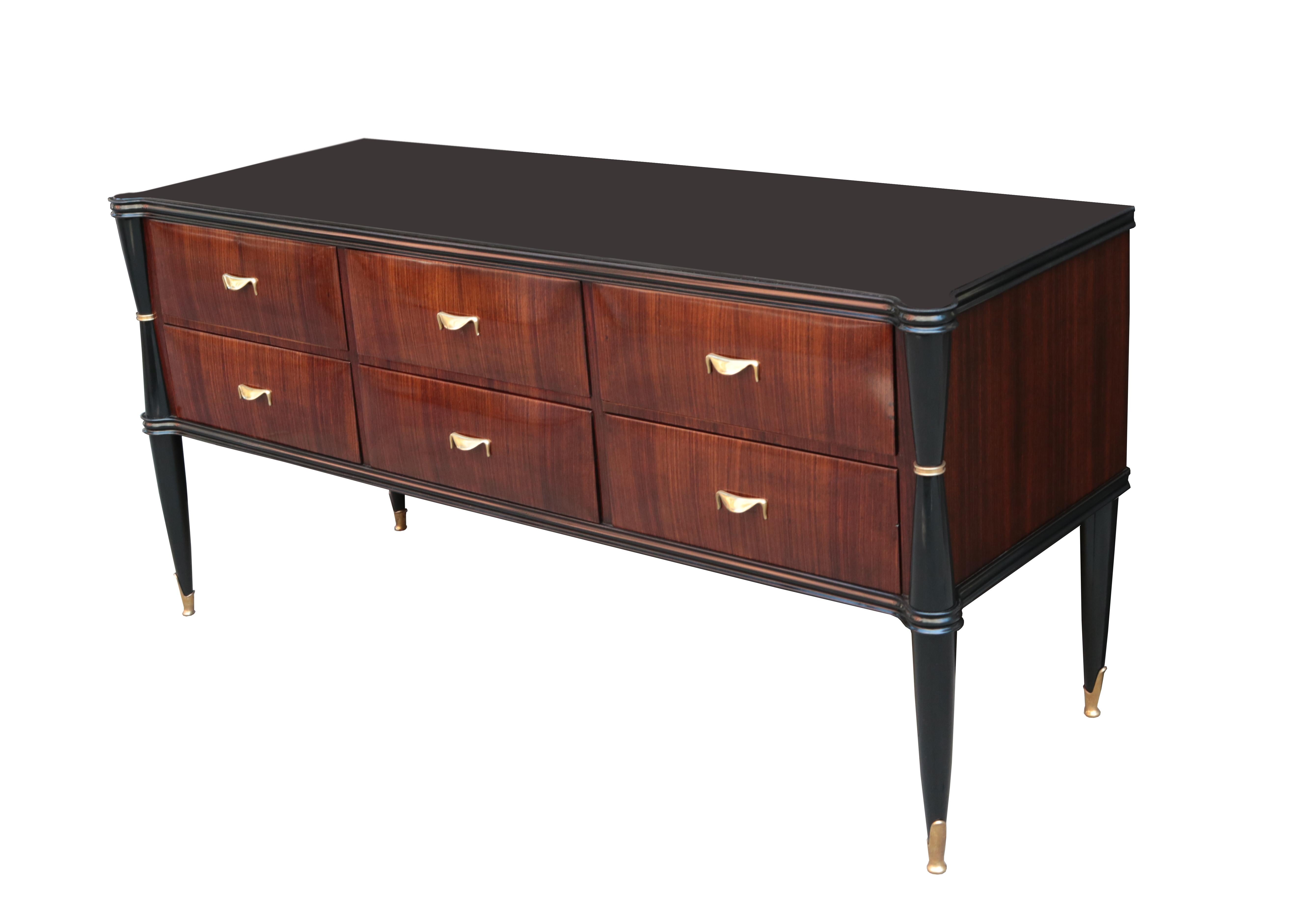 An Italian six drawer commode.
Mahogany with ebonized details,
patinated brass pulls and sabots,
with a black glass top.
 