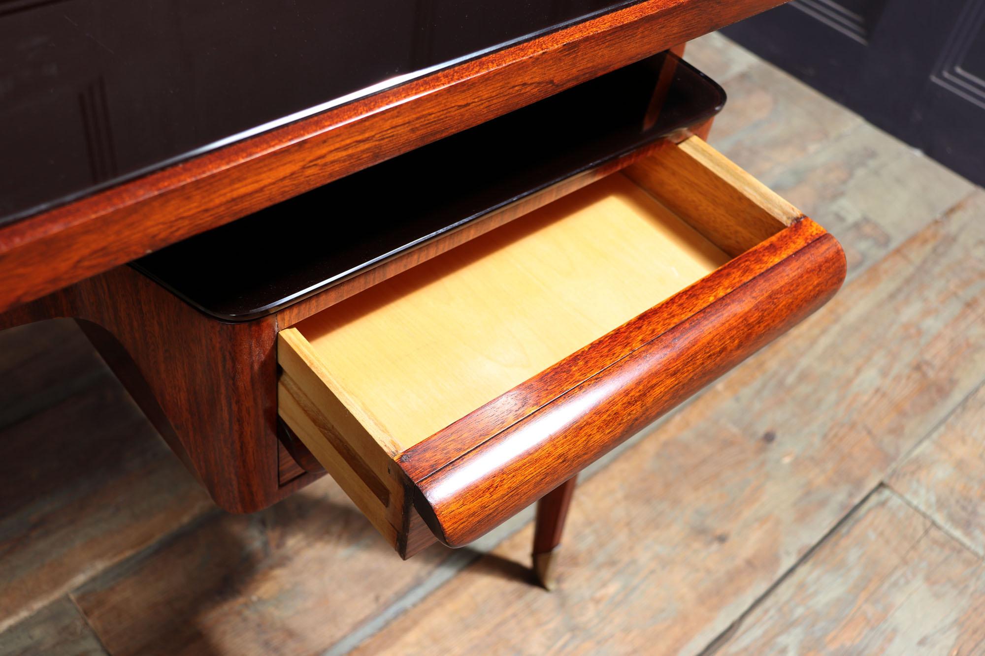 Midcentury desk by Dassi
A small desk created by Vitorrio Dassi in Italy in the 1950s, Minimalist in design the desk has two drawers that are part of the lower dark coloured shaped glass topped shelf, that is supported by the v shaped legs having