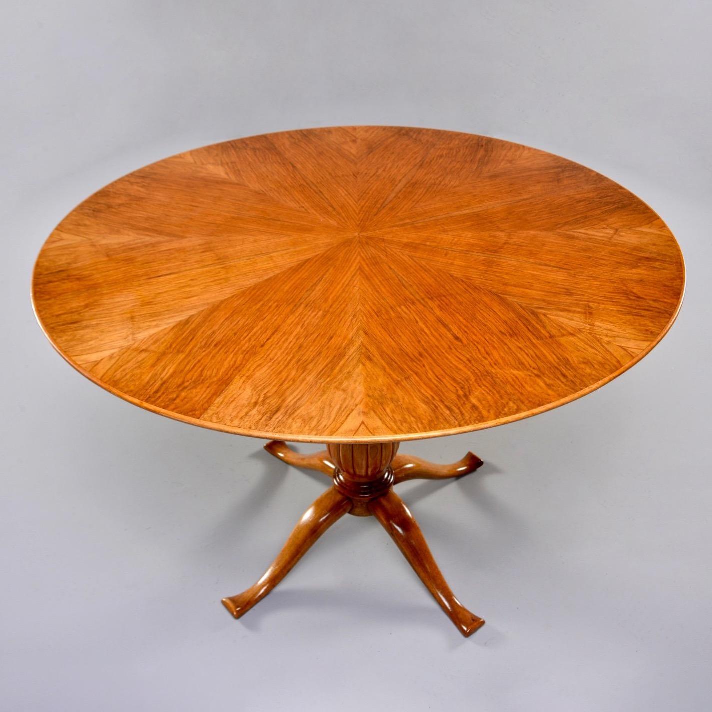 Italian small round beech table has a four legged pedestal base and urn shaped center column with reeded surface, circa early 1960s. Round tabletop is 43” in diameter and features a veneer starburst pattern. Unknown maker.

Knee Clearance: 29”.
  