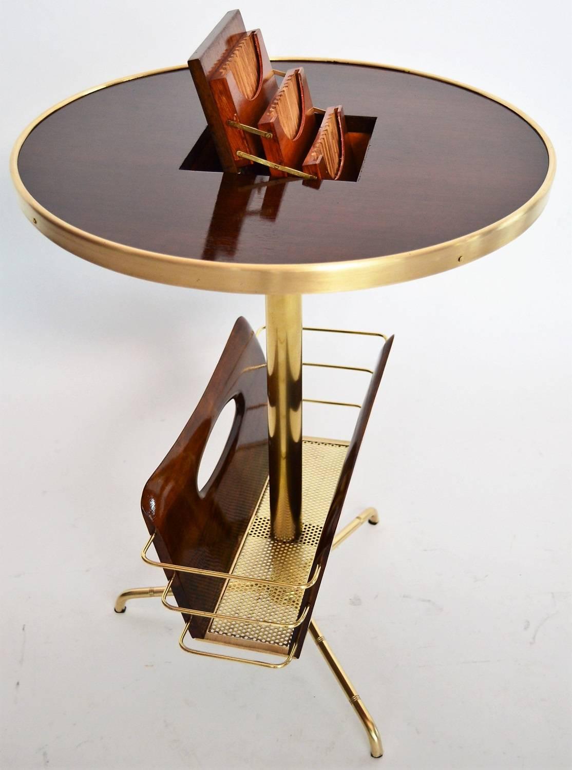 A very special smoking table with magazine rack made of different woods and full brass parts.
The round tabletop made of mahogany wood veneer is closed at the edge with a polished brass cover.
In the middle of the tabletop is a retractable door,