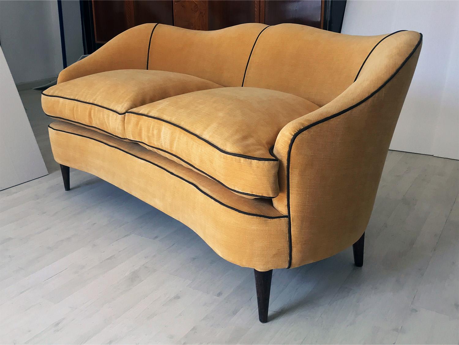 This stunning Italian sofa of the 1950s is very stylish, with two seats extremely comfortable upholstered in a gorgeus yellow velvet with striped texture and a very sturdy structure supported by conical wooden legs.
It’s a very well designed and