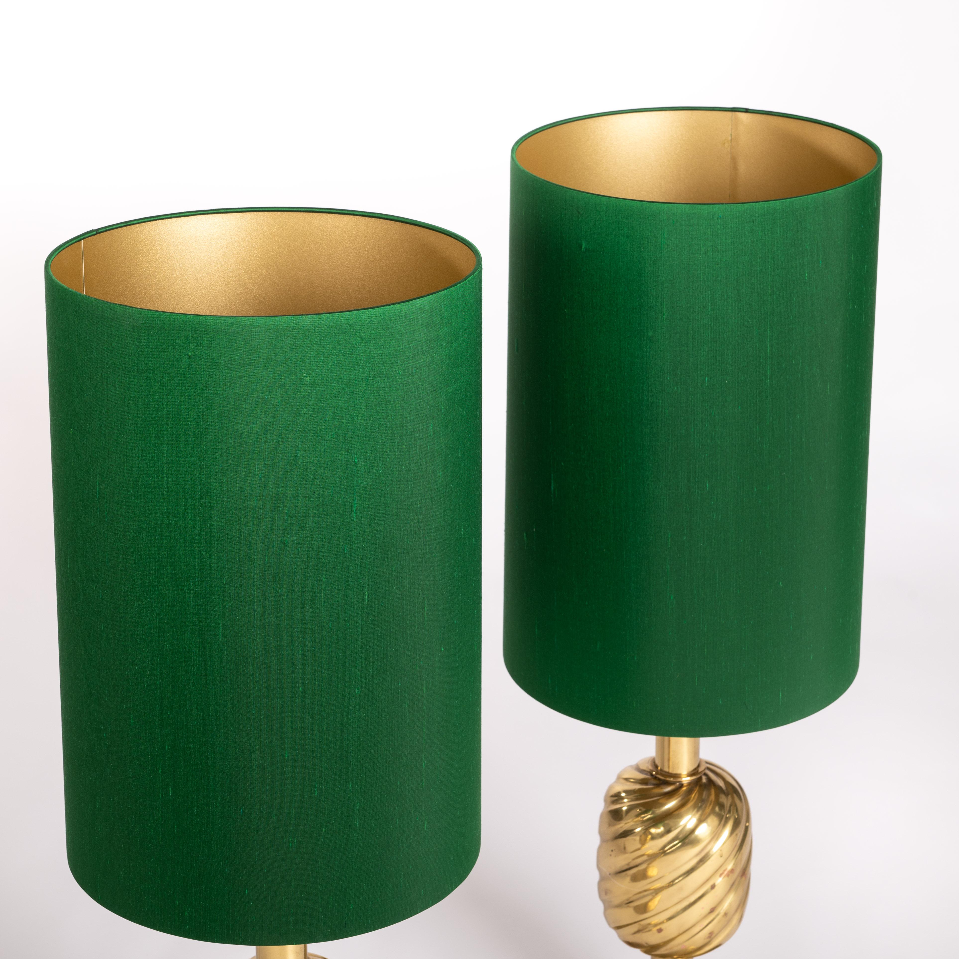 Italian mid-century solid brass pineapple table lamps with emerald green silk shades from the 70s.
Heavy brass table lamps in the shape of a pineapple. 
The foot batten is a bit overemphasized, the body is designed in a long style. 
The shades takes