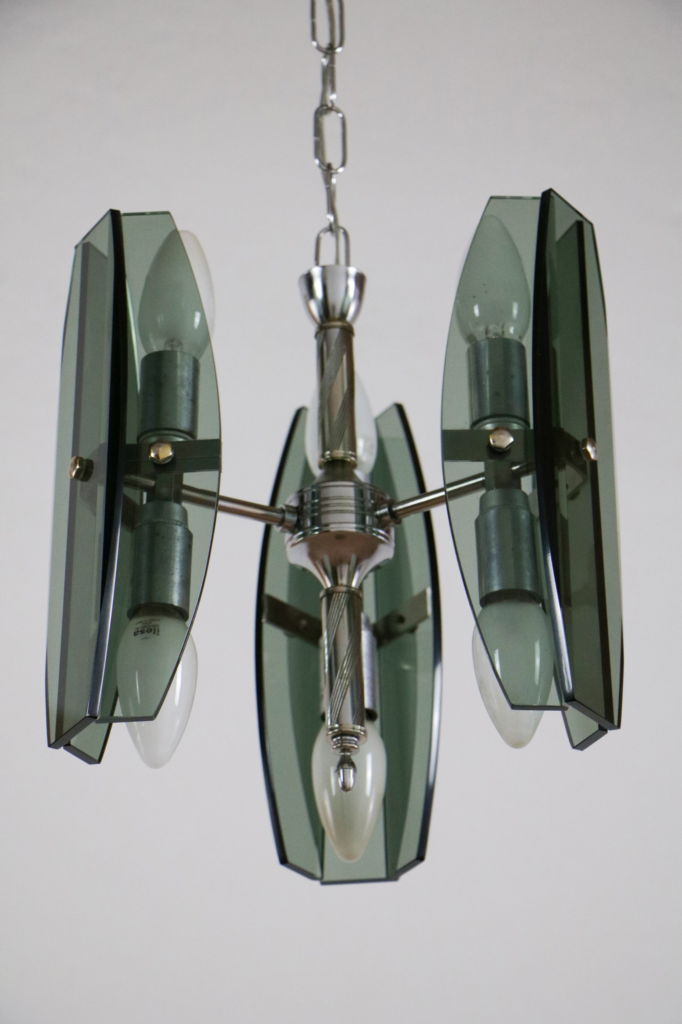 A stylish Italian midcentury pendant lamp or chandelier from the 1970s, in the Veca style by Fontana Arte. The pendant lamp or chandelier is made of chromed brass and steel, surrounded by crystal panels in green bottle color. The electrical system