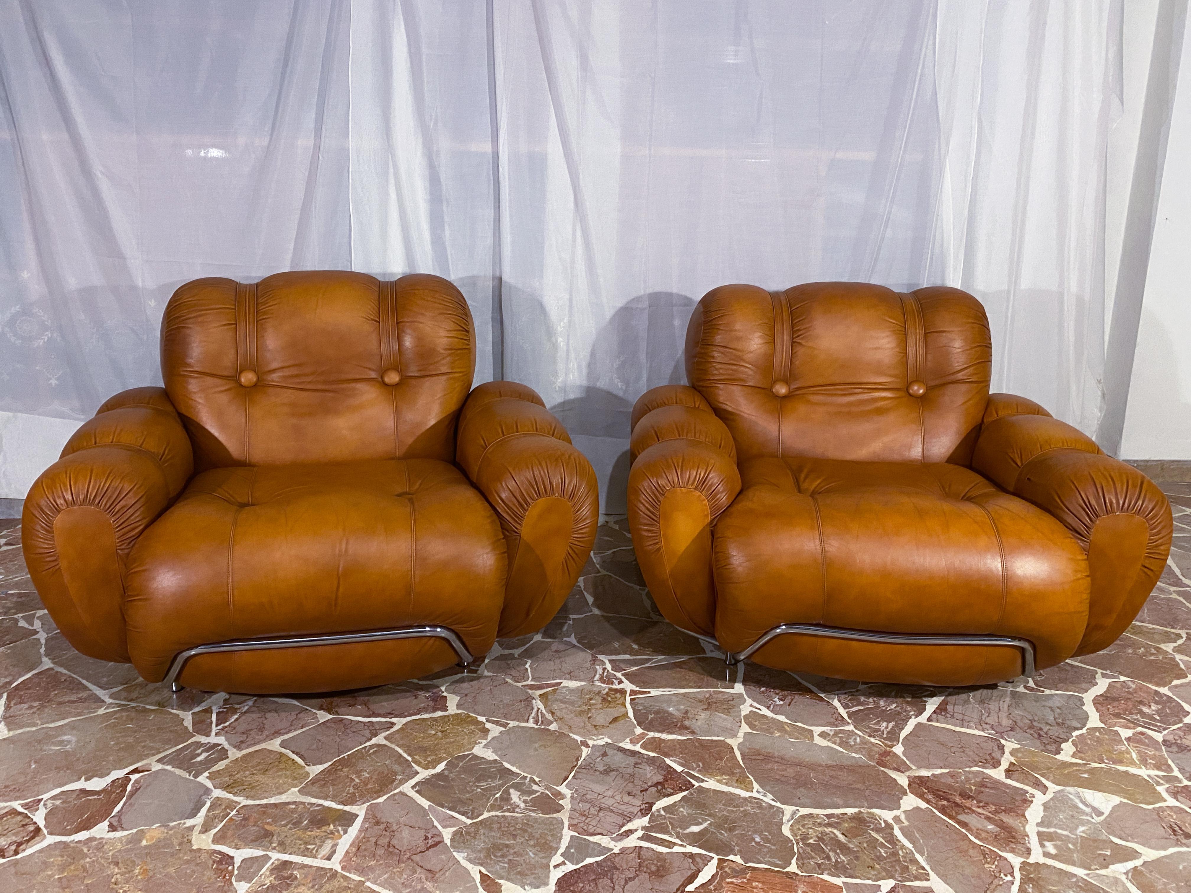 Splendid living room set composed of the three-seater sofa and a pair of armchairs made in Italy in the 70s. The seats are very comfortable and supportive. The pads are still original and in very good condition. Original natural leather upholstery