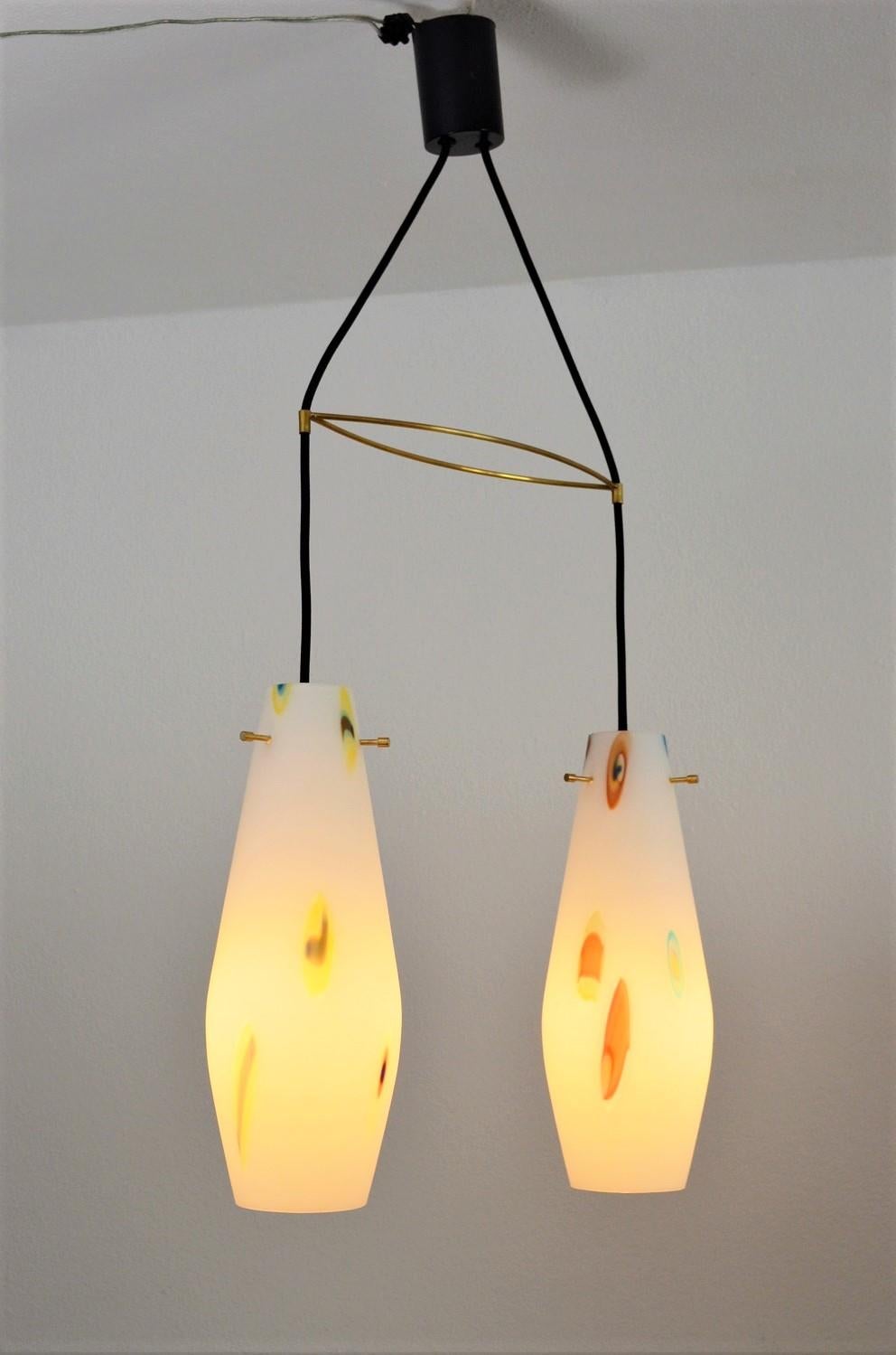 Superbe lampe suspendue avec deux verres.
Fabriqué en Italie par Stilnovo dans les années 1970.
À l'intérieur des verres laiteux sont fondus des éléments de verre 