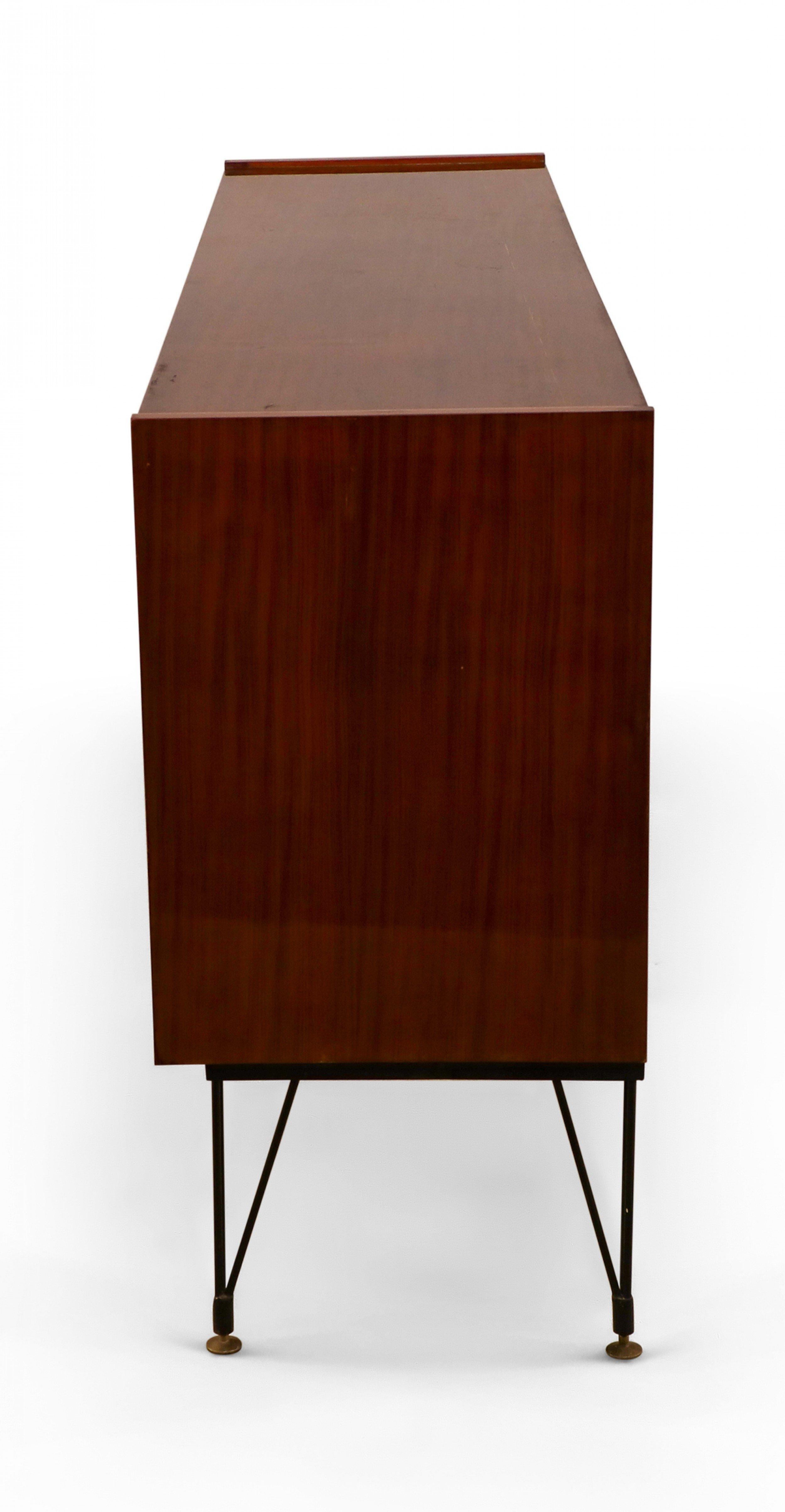 Mid-Century Modern Italian mahogany sideboard with a striped veneer exterior, 4 cabinet doors, brass handles, and a center cabinet with a mosaic mirrored interior with a brass pull that becomes a leg, and 6 black metal hairpin legs with brass
