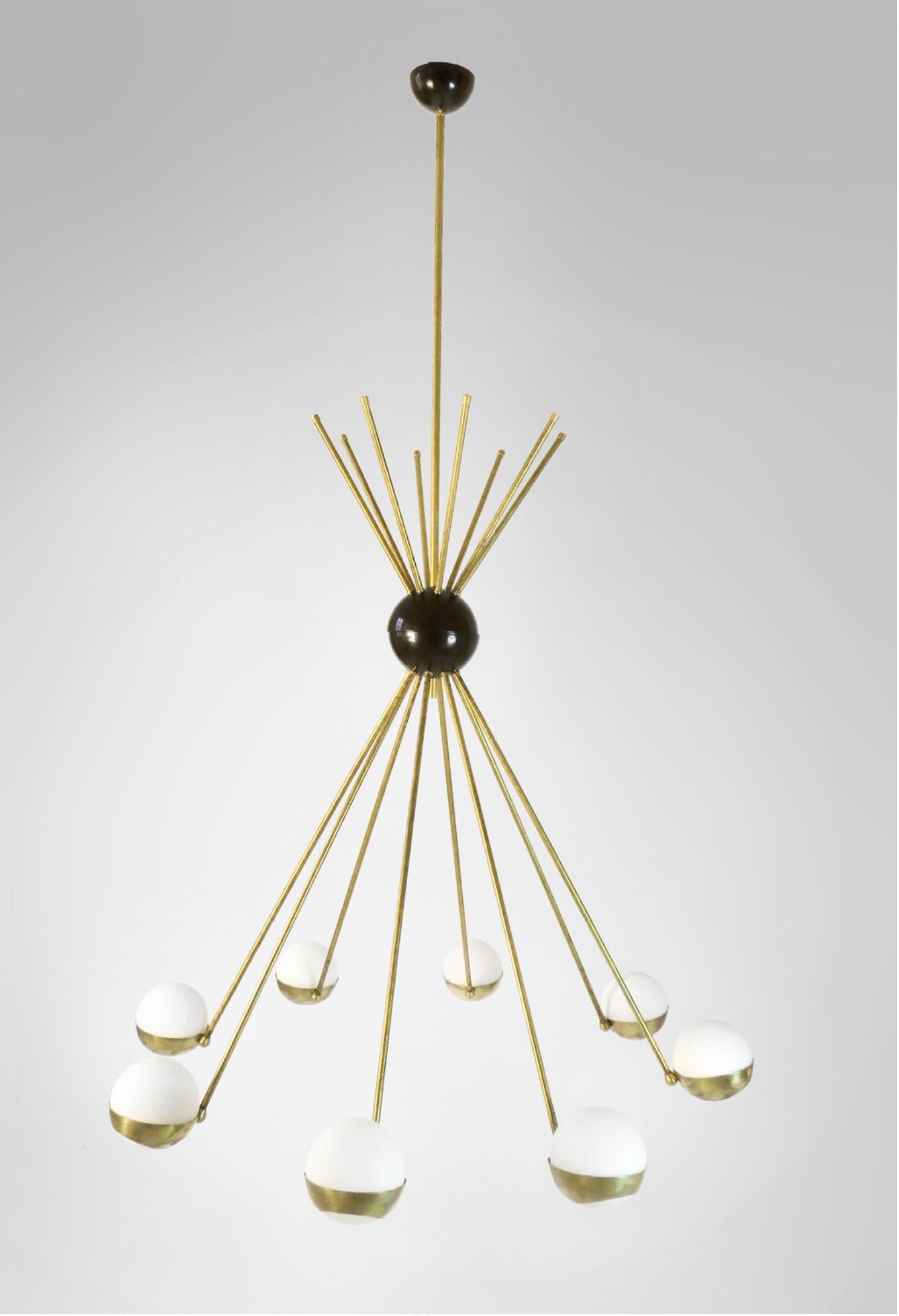 Elegant Italian mid century style eight globes opaline glass and brass chandelier with hand rubbed antique treated brass frame. A statement chandelier which will elevate any room with a sophisticated design. Opaline glass globes, black central ball