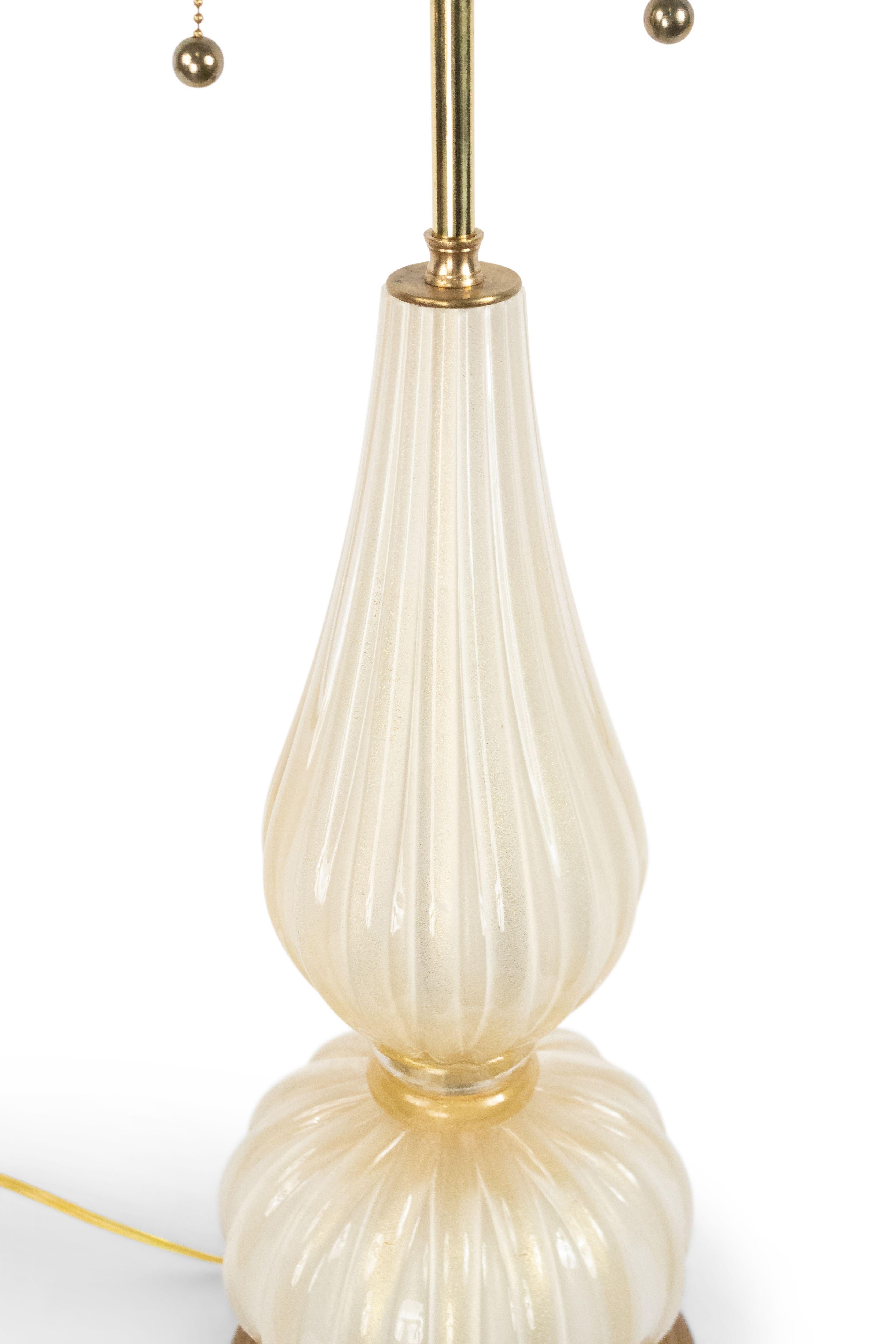 Italian 1940s style white glass and gold dusted table lamp with a large fluted ball base over a shaped fluted section and resting on a modern round wood base.