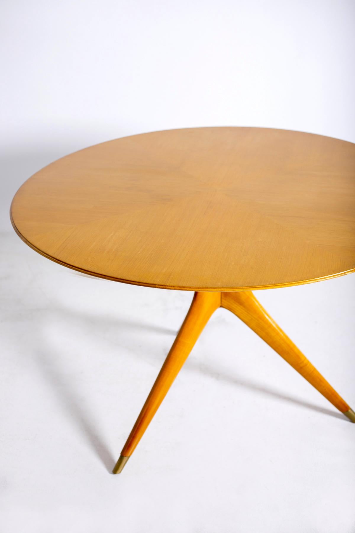 Round table designed by Ico Parisi in 1950 for the Fratelli Rizzi factory. The table is supported by an elegant radiated structure in solid walnut wood. The three tapered legs, ending on the ground with brass tips, cover upwards and join at the