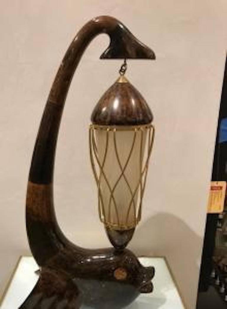 Italian Mid-Century table lamp with a brown parchment veneer in the shape of a dolphin holding a lantern from its tail (ALDO TURA)
