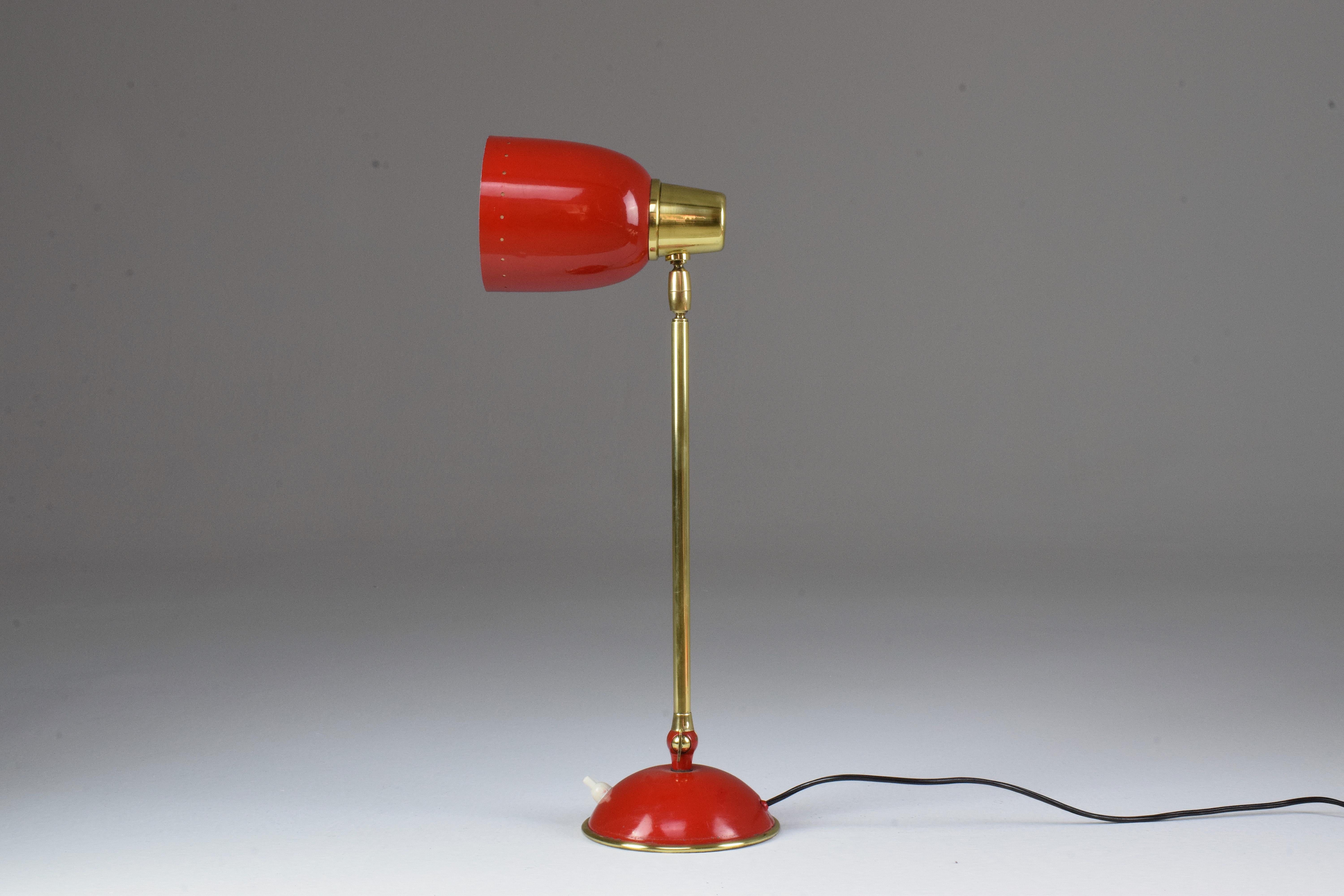 Eine schöne italienische Tisch- oder Schreibtischlampe aus dem 20. Jahrhundert aus rot lackiertem Stahl mit schicken Messingdetails. Diese Statement-Leuchte ist am Sockel und am Schirm artikuliert. Druckknopf-Lichtschalter am Sockel.
Nach dem