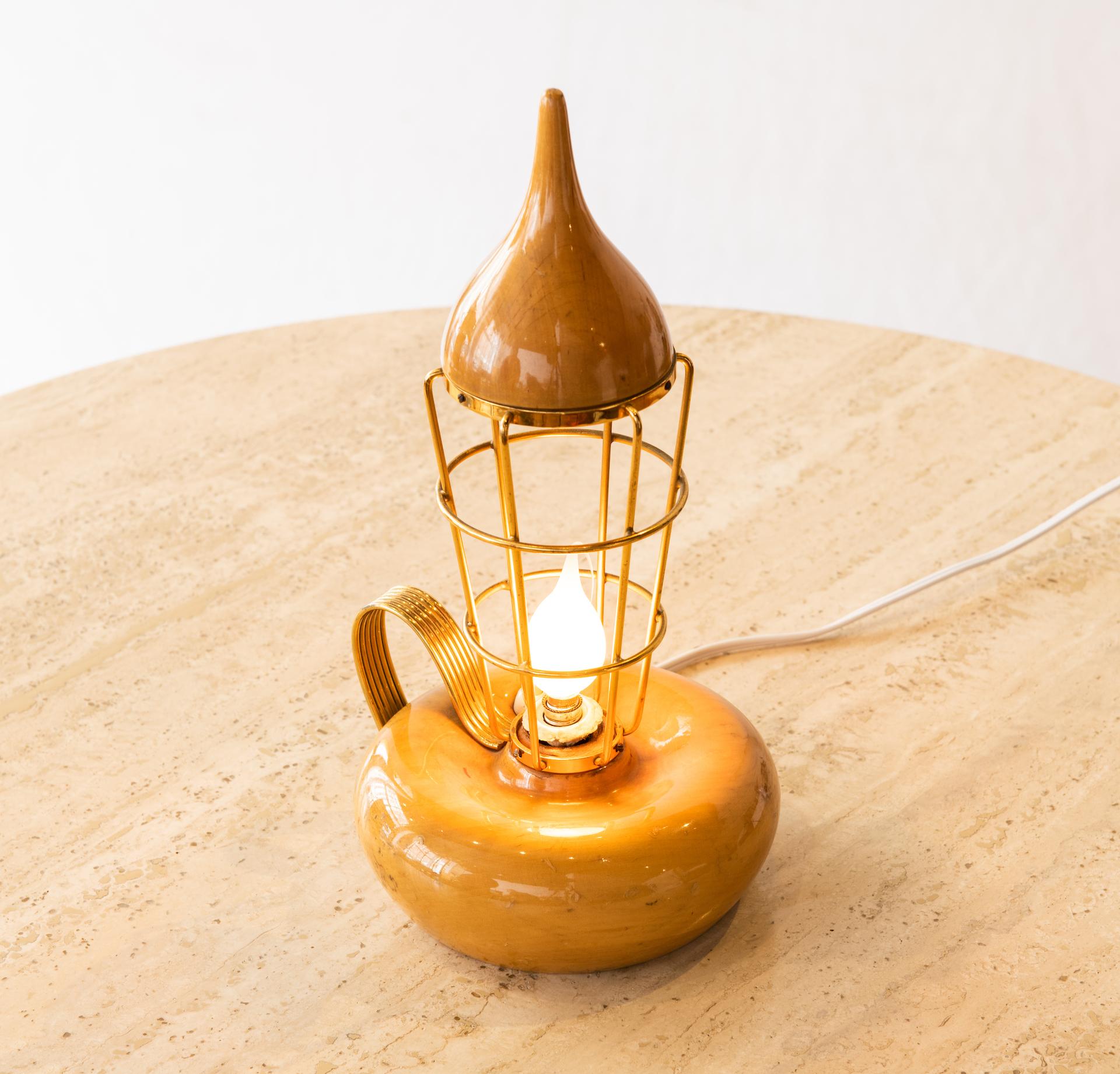 Mid-Century Modern turned burl olive wood lantern table lamp with brass bulb cage and handle. In original condition with original foil label.

Born in 1909, Italian designer-maker Aldo Tura established his furniture production house in Lombardy in