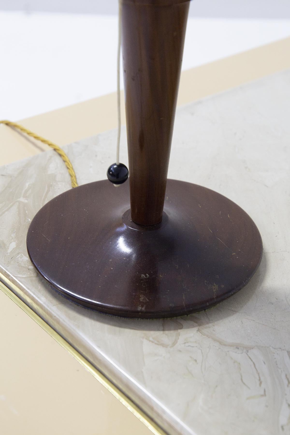Jolie lampe de table italienne avec cadre en bois produite par une manufacture italienne dans les années 1950.
La lampe est belle et très unique : elle présente une structure à la base ronde avec une tige centrale en bois foncé, très délicate et