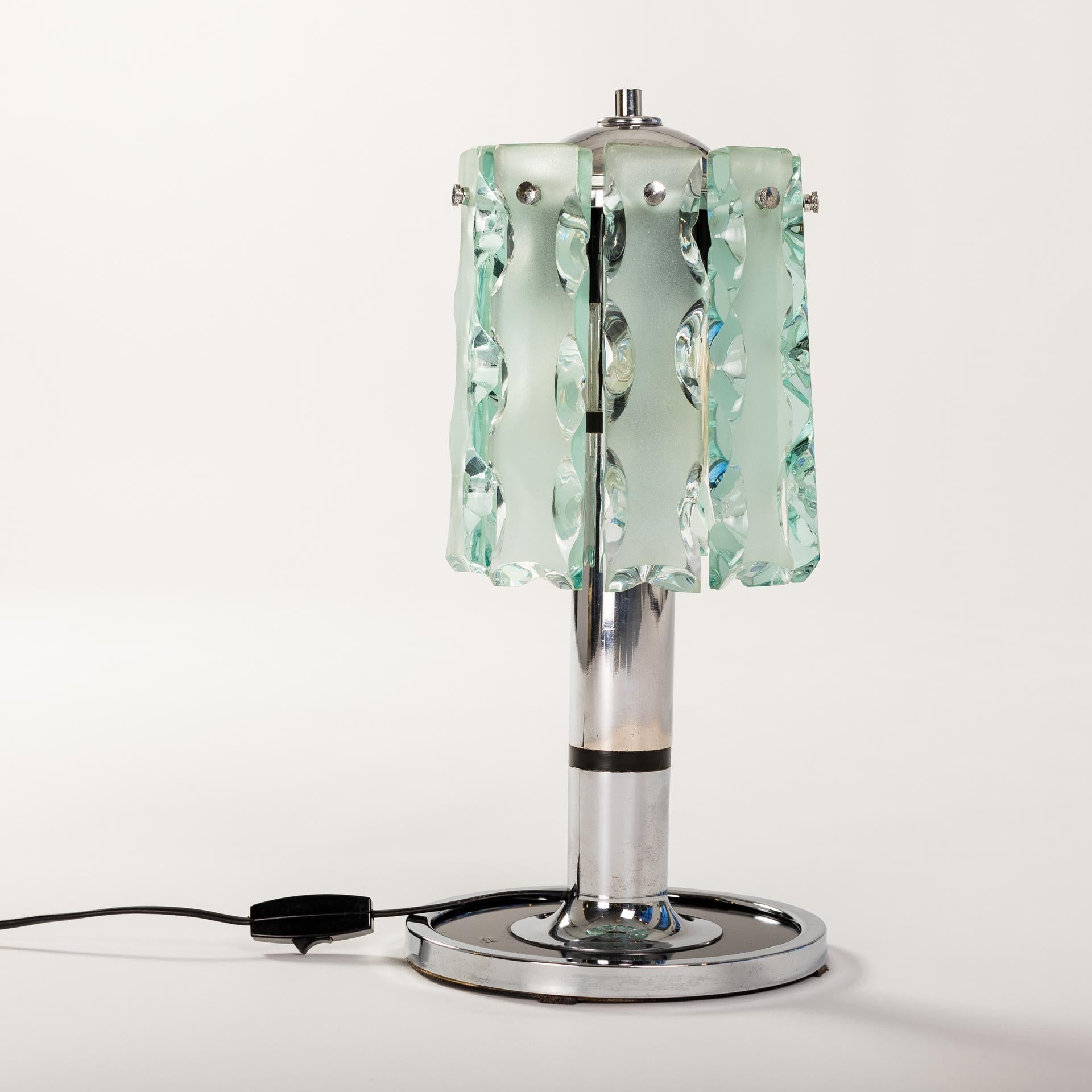 Small table lamp with nickel-plated metal base and pieces of green Fontana Arte glass (Verde Nilo Color) as a shade. 
Fontana arte Zero Quattro anni 60/70
The handmade pieces of glass have the following dimensions: 10cm x 4cm x 1.5cm.
The surface is