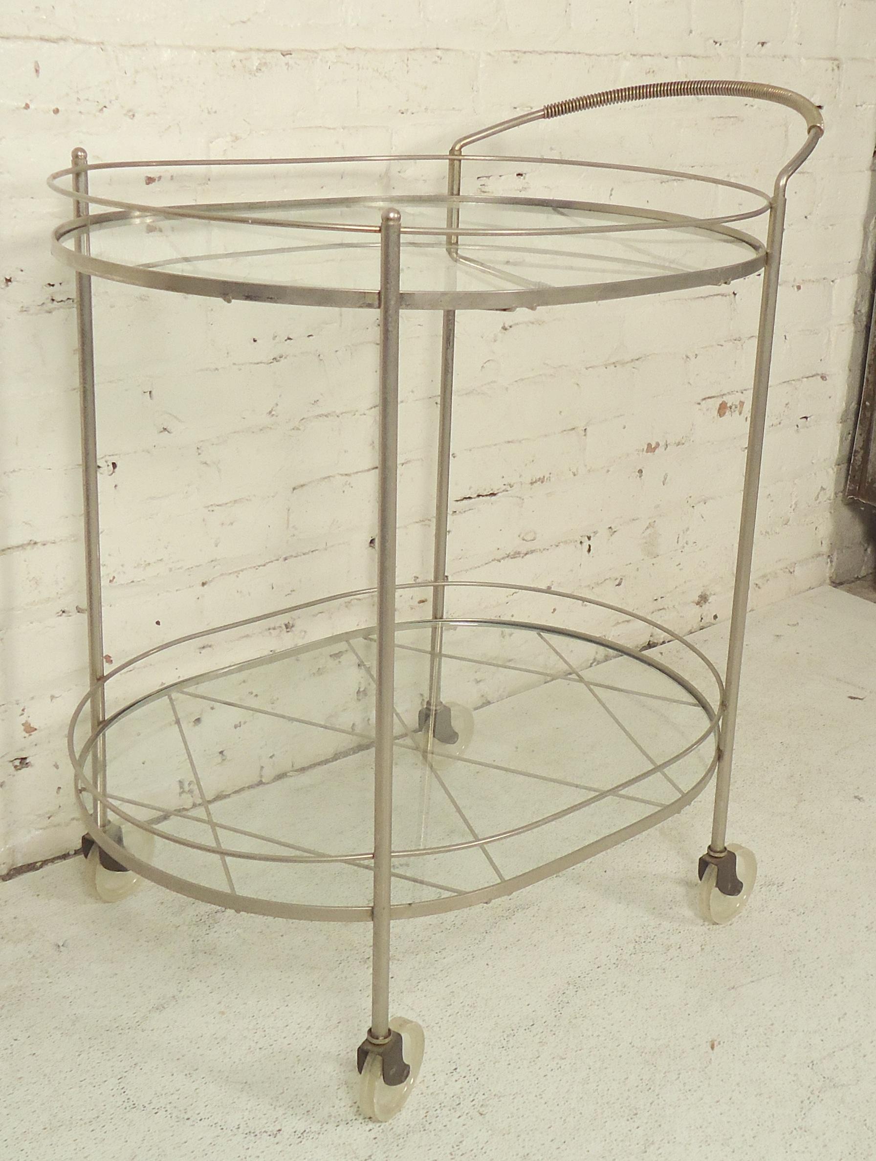 This is a great vintage bar cart with two glass shelves set on criss-cross metal. 

(Please confirm item location - NY or NJ - with dealer).
  