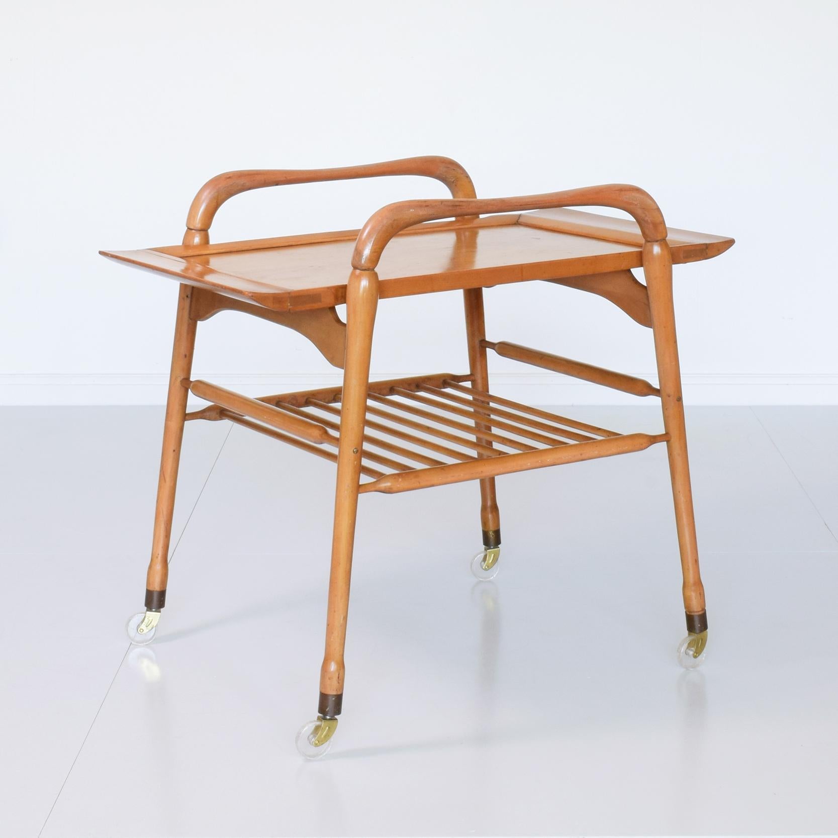 Beautiful mid-century Italian serving trolley with removable tray, circa 1955.

Sculptural wooden form, removable tray with rubber 'feet', castors, brass fittings.

Condition: vey good original unrestored condition. Wooden frame is clean and