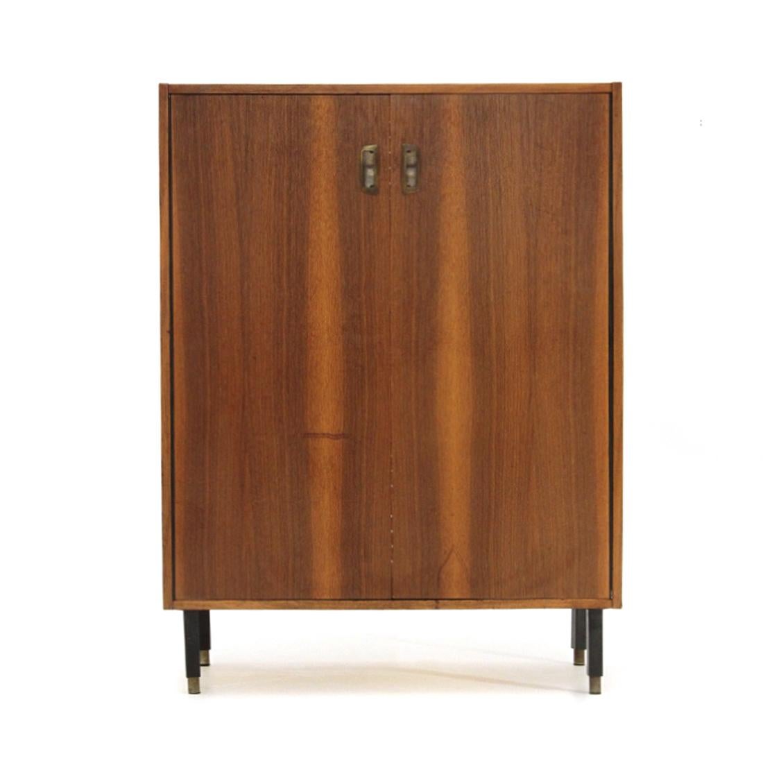 Italian-made shoe cabinet produced in the 1950s.
Structure in teak veneered wood.
Brass handles.
Shoe rack made of plastic tubes adjustable in different positions.
Legs in black painted metal, with terminal in knurled aluminum, adjustable in