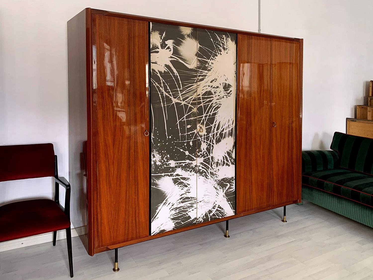 Stunning Italian Armoire 5-door well designed by Vittorio Dassi in the 1950s.

The cabinet is made of a beautiful lacquered teakwood, supported by black metal legs finished with adjustable brass feet.

All interiors are made of maple, offering