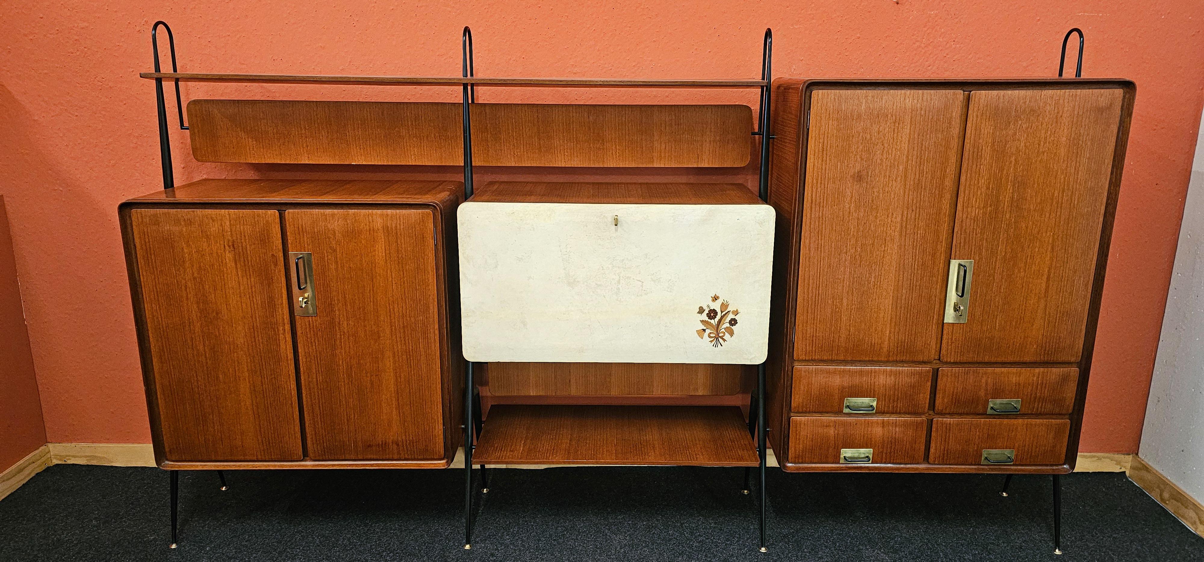 Splendida credenza da salotto italiana in legno di teak disegnata e prodotta da Silvio Cavatorta negli anni Cinquanta.
L'intera struttura è sostenuta da quattro montanti in metallo verniciato nero e i due armadi laterali sono dotati di ante a