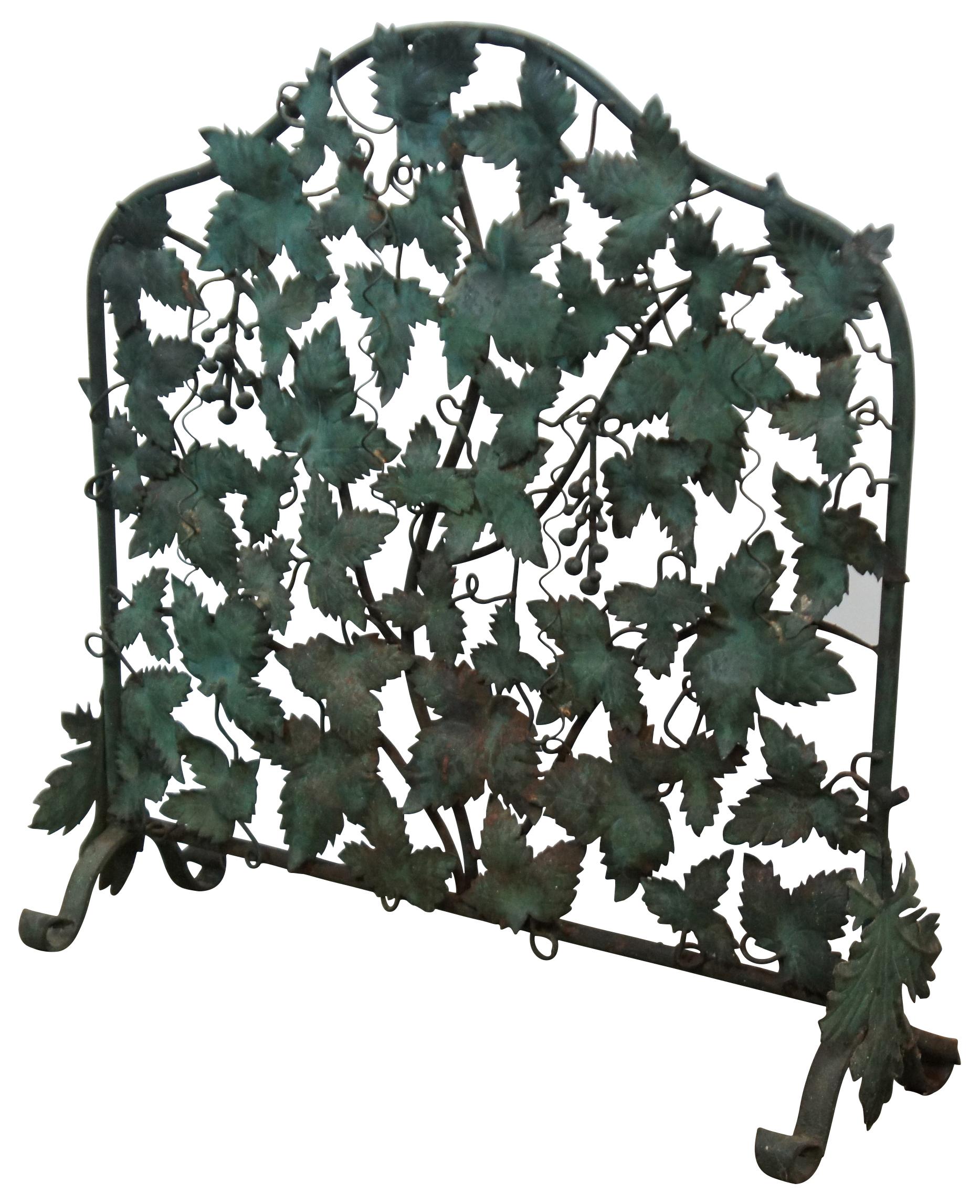 An exquisite Mid-Century Modern Italian wrought iron single panel fireplace screen shaped like a wall of grape vines / leaves with small bunches of grapes, finished in green. Marked along back 