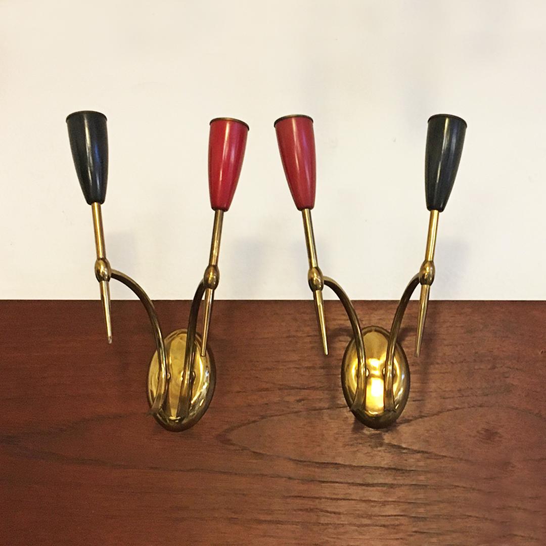 Italian mid-century two-arm brass wall lamps with cone lamp holder, 1950s
Two-arm wall lamps with brass structure and respective cone lamp holder in red and black, 1950s

Four pieces available, good conditions

Measures 20 x 15 x 28 H cm.