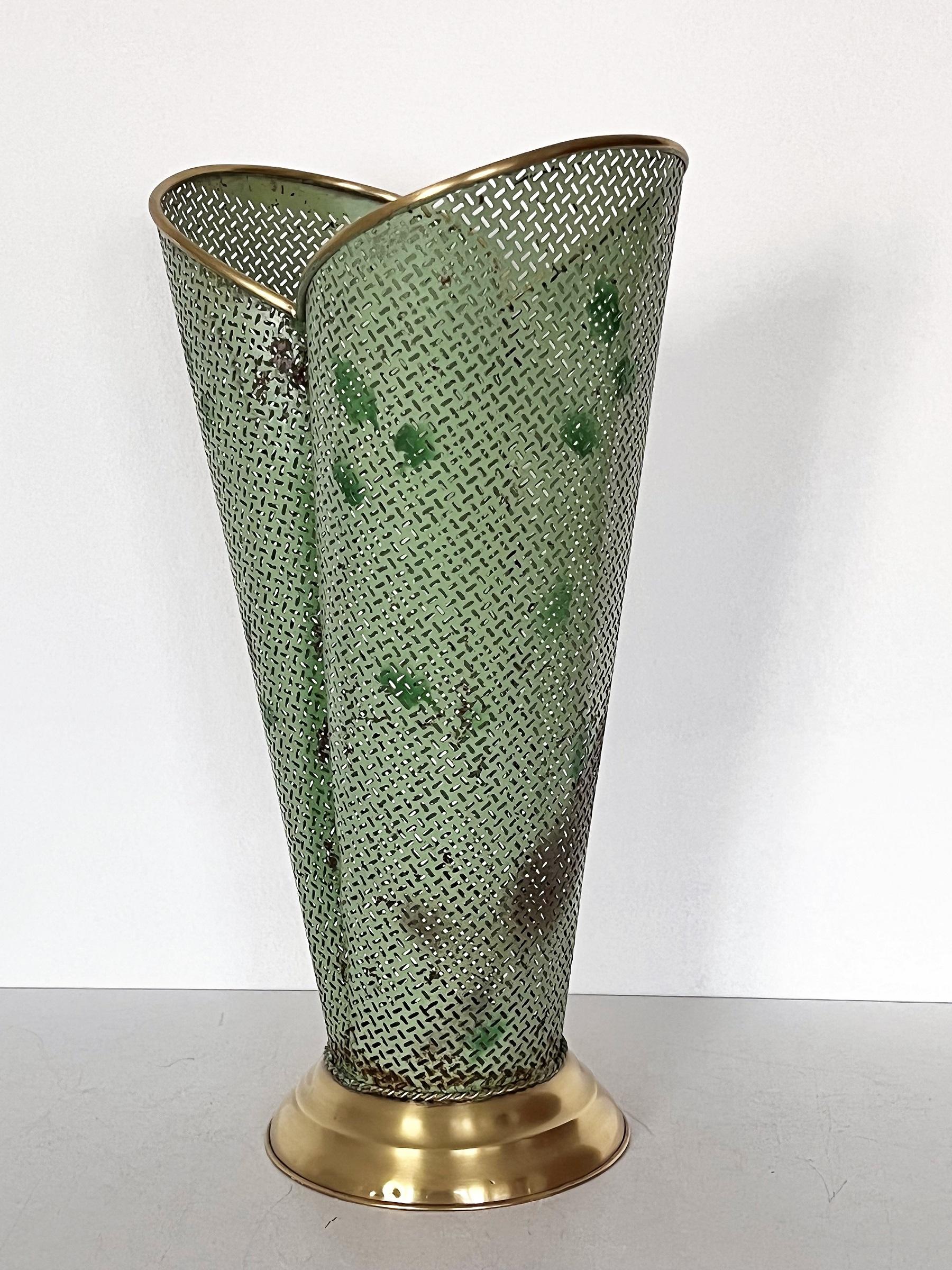 Beautiful umbrella stand, Made in Italy in the mid-century.
Made of perforated sheet metal with shiny brass borders and shiny brass base.
The perforated metal is lacquered in light green color with dark green color spots and rusty spots