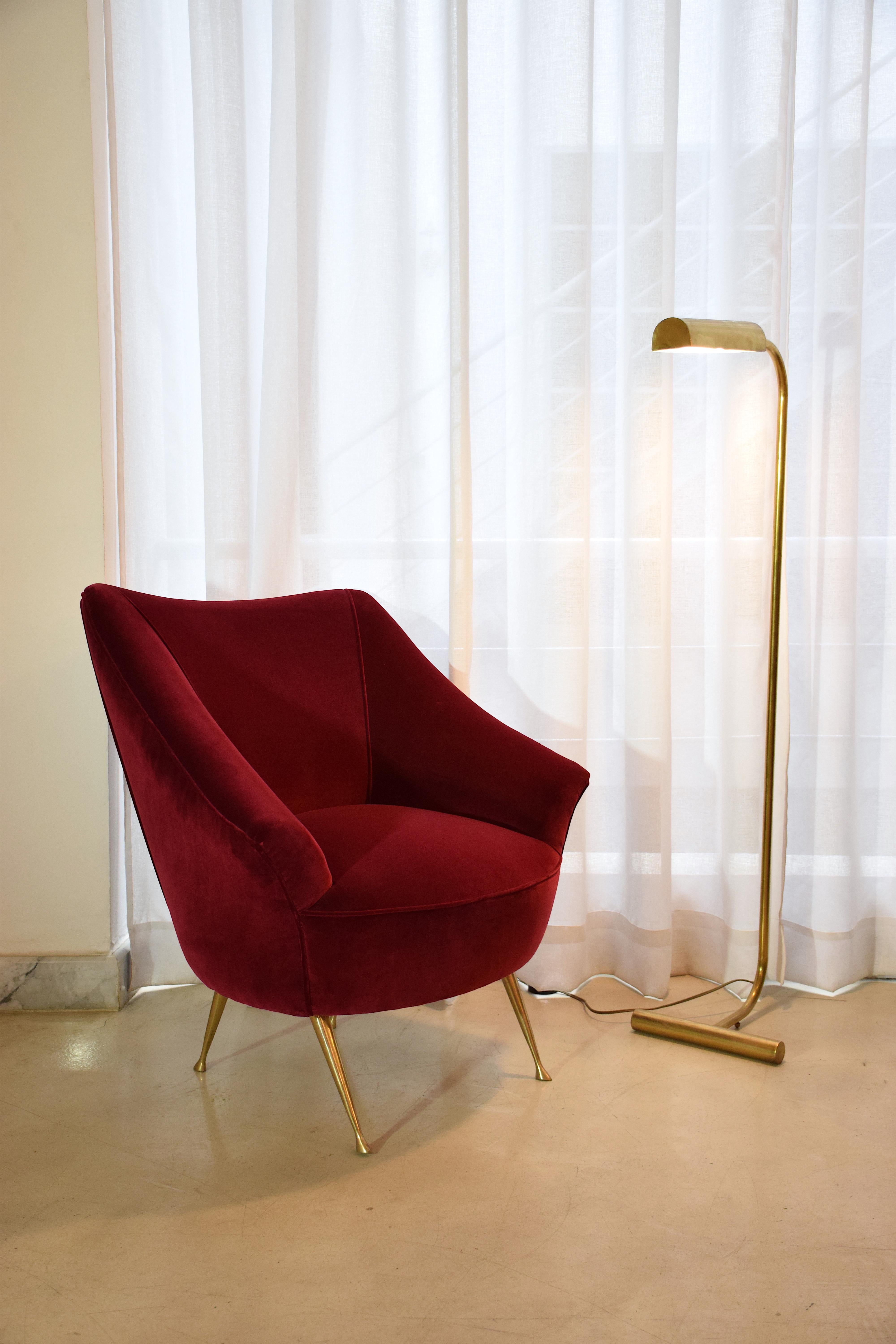 An Italian 20th century vintage brass-legged, curved armchair fully restored with one of the highest quality French upholstery makers, Lelièvre Paris in red velvet. 
The sophisticated brass legs have been carefully polished. 
A two-seater sofa of