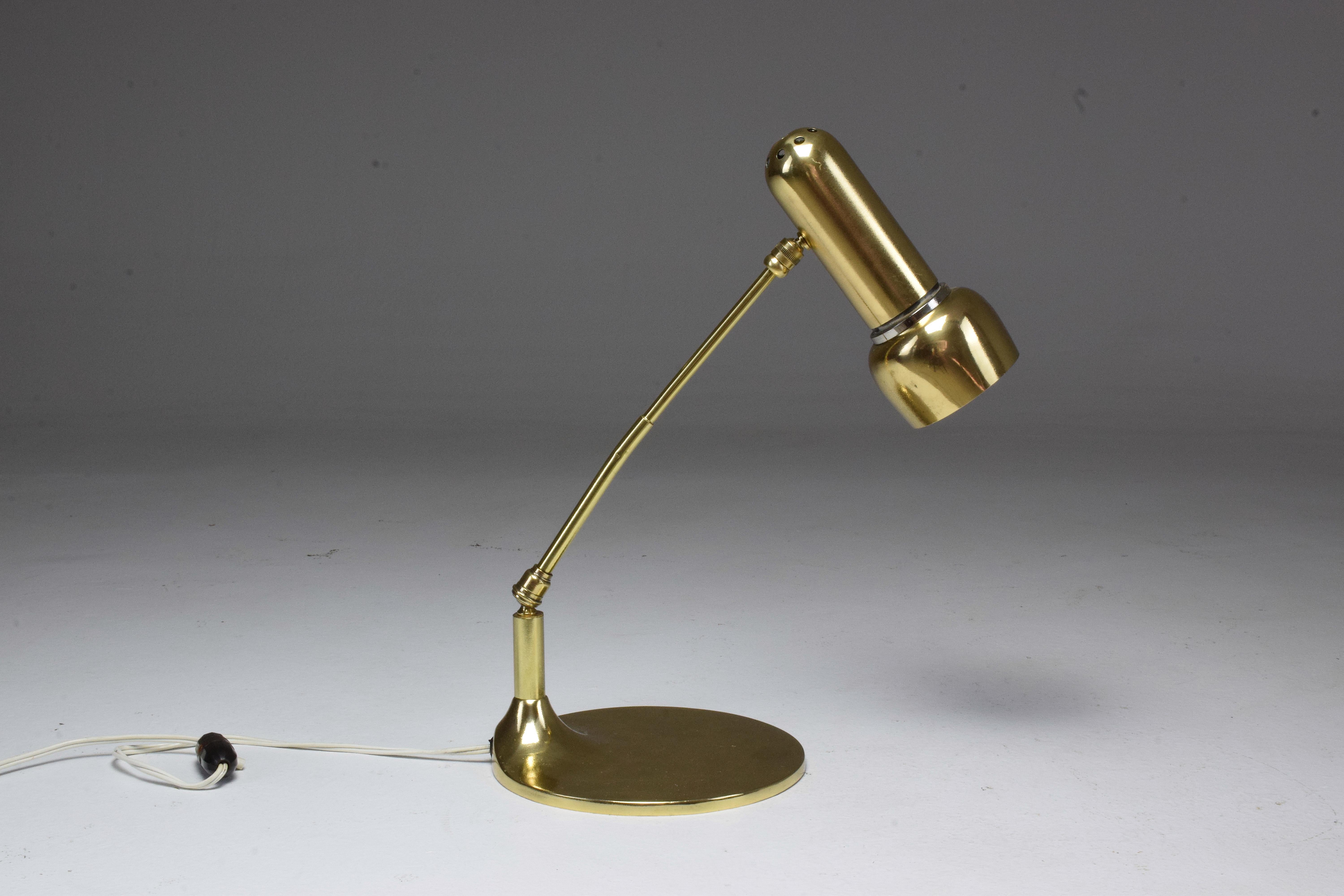 20th century vintage Italian table accent or desk lamp which articulates at the base and the shade designed in an organic aged brass structure of Industrial style.
Italy, circa the 1950s.

We are an exhibition space and an online destination